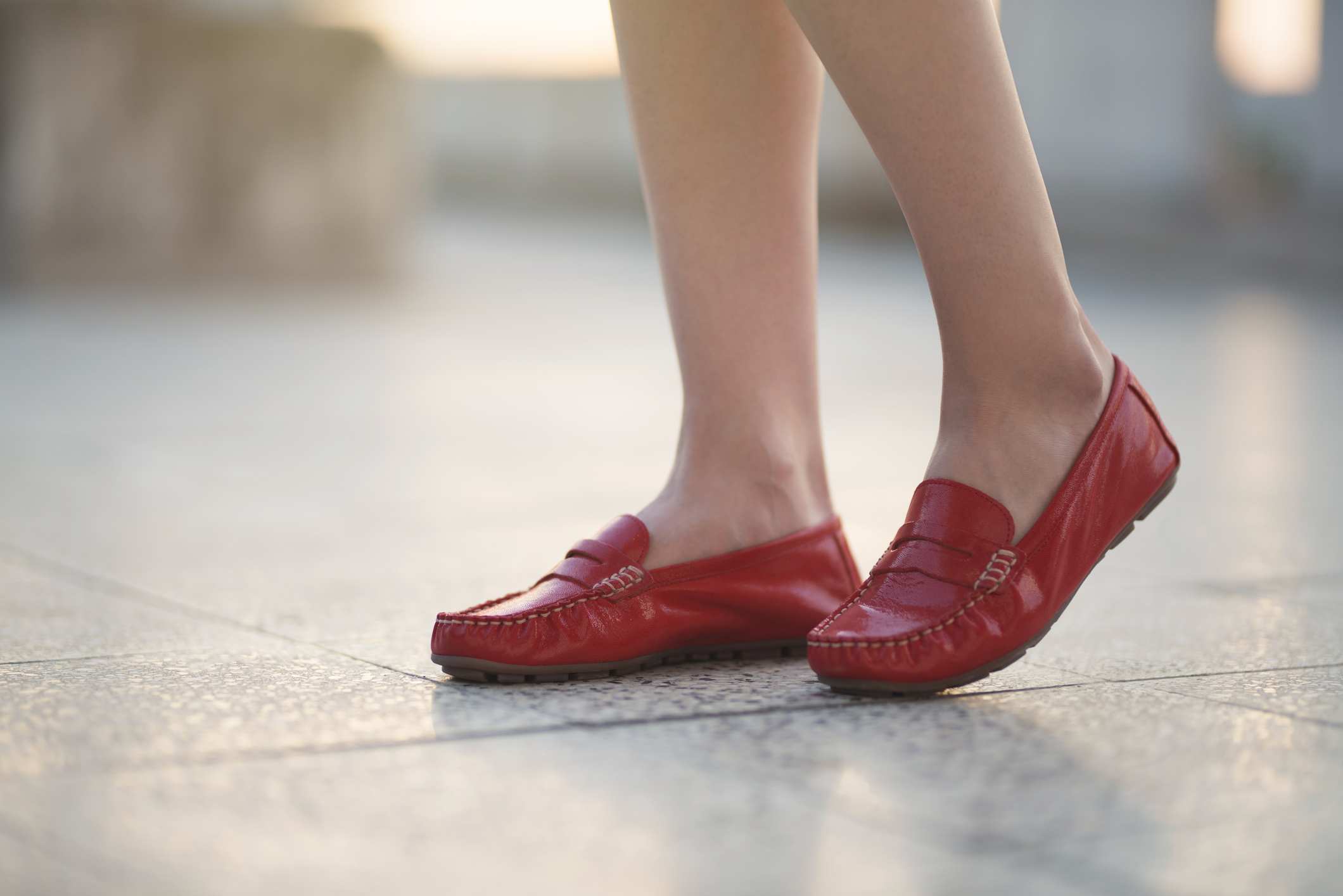 Woman feet in red leather moccasin.