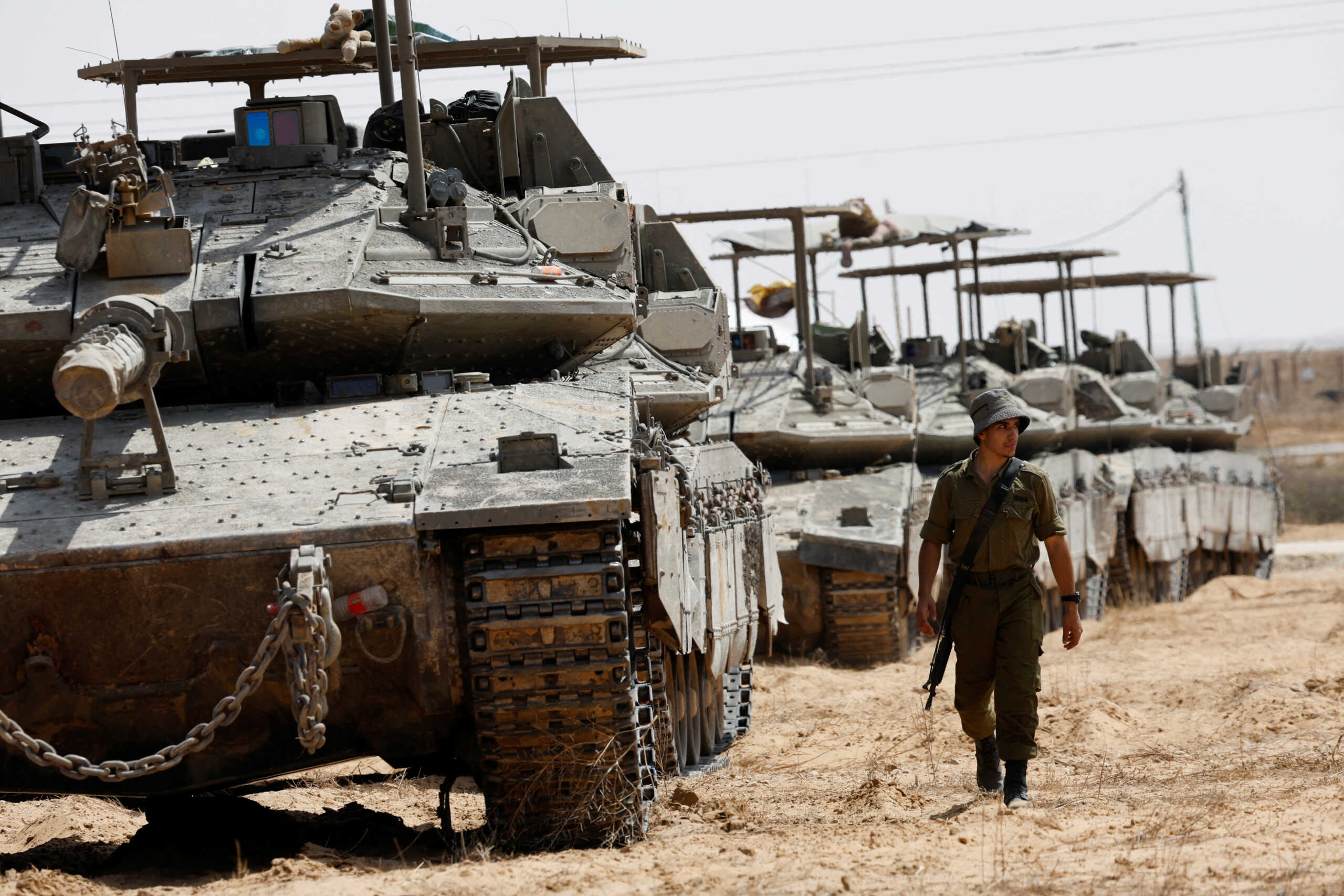 An Israeli soldier walks near tanks parked near the southern Israel-Gaza border, amid the ongoing conflict between Israel and the Palestinian Islamist group Hamas, in Israel, April 28, 2024. REUTERS