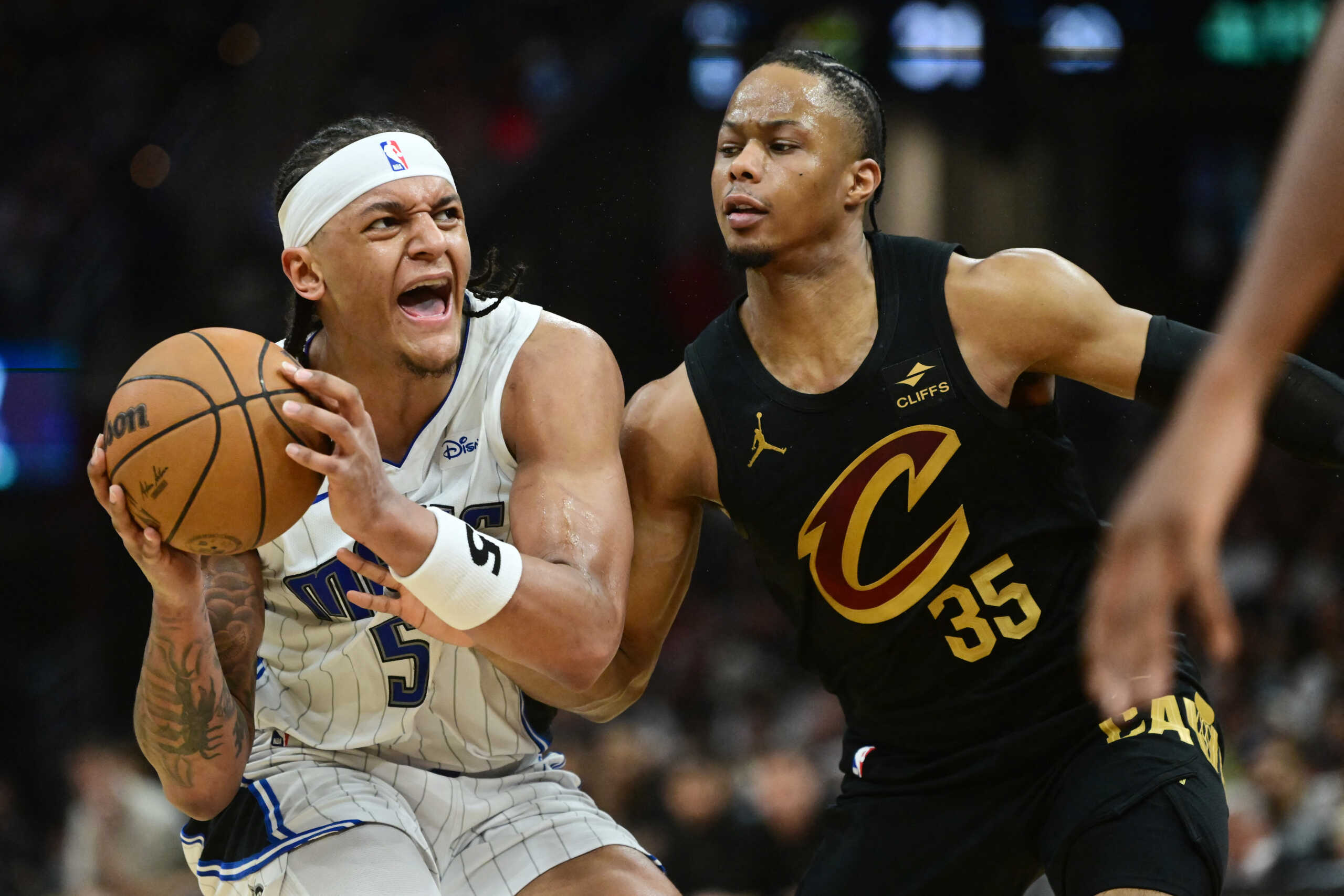 May 5, 2024; Cleveland, Ohio, USA; Orlando Magic forward Paolo Banchero (5) drives to the basket against Cleveland Cavaliers forward Isaac Okoro (35) during the first half in game seven of the first round for the 2024 NBA playoffs at Rocket Mortgage FieldHouse. Mandatory Credit: Ken Blaze-USA TODAY Sports