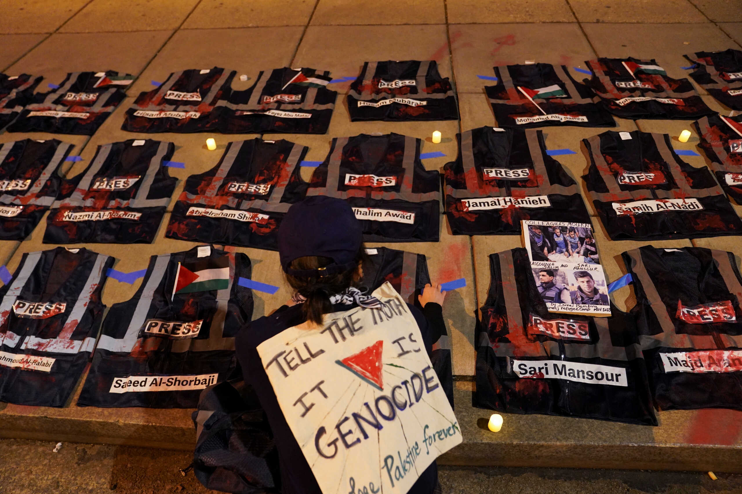 A protester kneels near vests representing bulletproof press vests, symbolic of journalists who were killed while covering the conflict between Israel and Palestinian Islamist group Hamas, during a protest in support of Palestinians in Gaza, near the annual White House Correspondents’ Association (WHCA) Dinner in Washington, U.S., April 27, 2024. REUTERS