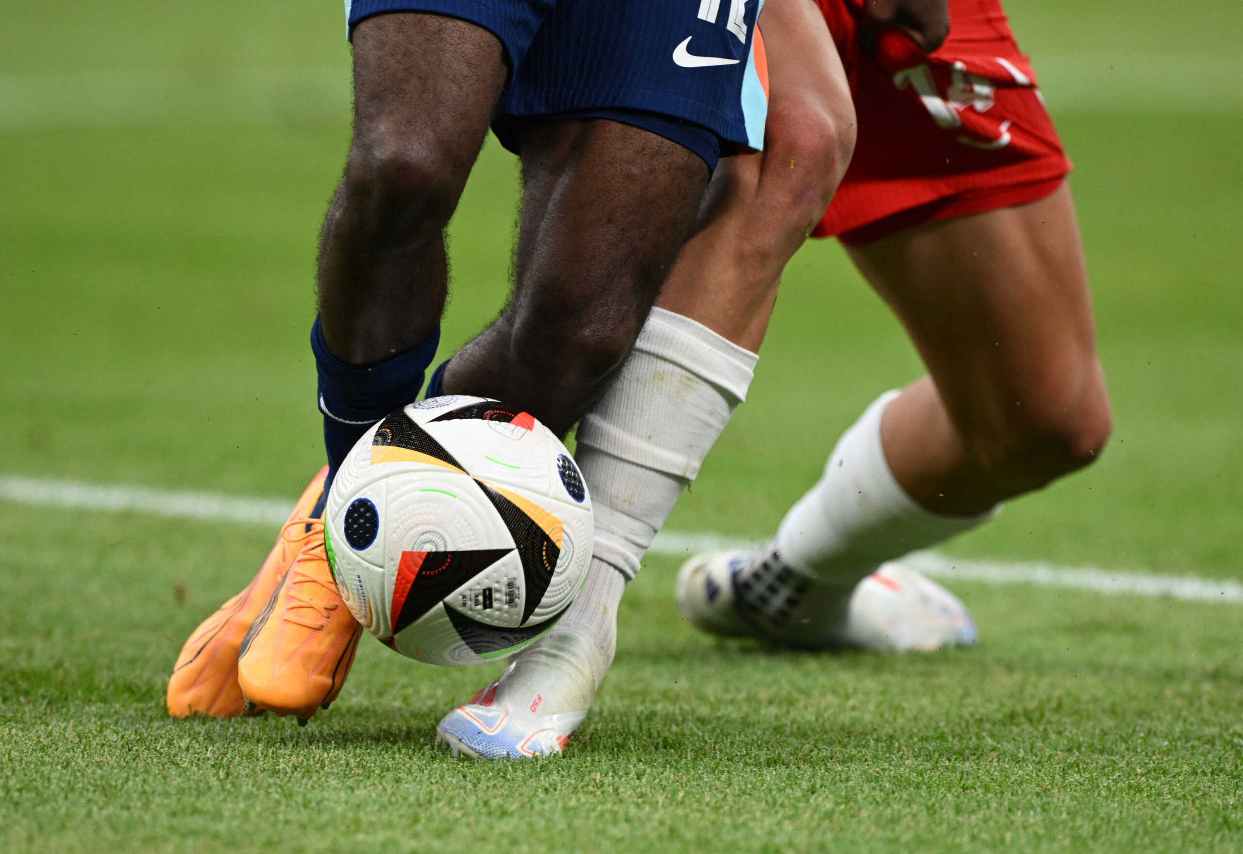 Soccer Football - Euro 2024 - Group D - Poland v Netherlands - Hamburg Volksparkstadion, Hamburg, Germany - June 16, 2024 A general view of the legs of Netherlands' Jeremie Frimpong and Poland's Jakub Kiwior as they challenge for the ball REUTERS