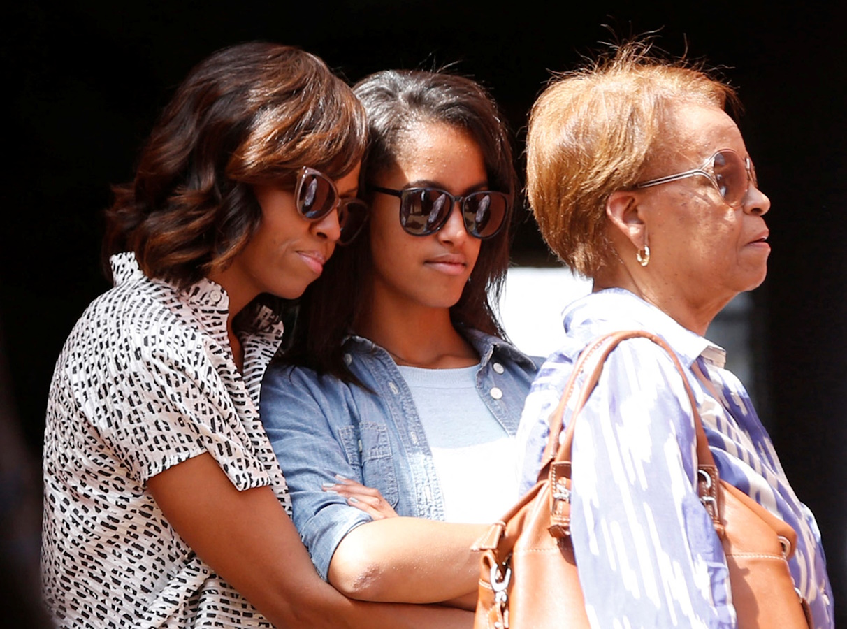 FILE PHOTO: U.S. first lady Michelle Obama hugs her daughter Malia alongside Marian Robinson, Michelle Obama's mother, as they visit the Maison Des Ecslaves, the gathering point where slaves were shipped west in the 1700s and 1800s, at Goree Island near Dakar, Senegal, June 27, 2013. REUTERS