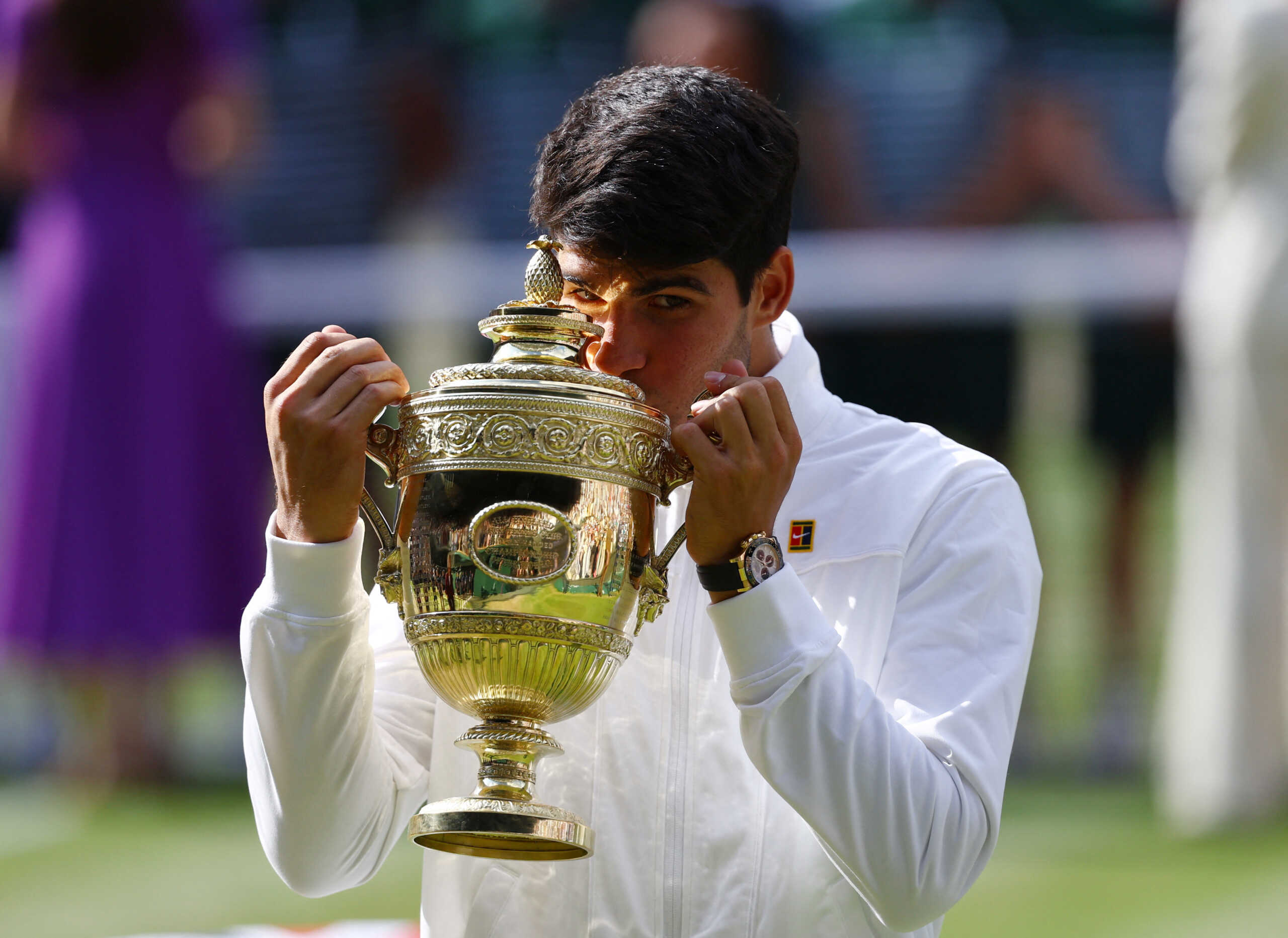 Tennis - Wimbledon - All England Lawn Tennis and Croquet Club, London, Britain - July 14, 2024 Spain's Carlos Alcaraz celebrates with the trophy after winning the men's singles final against Serbia's Novak Djokovic REUTERS