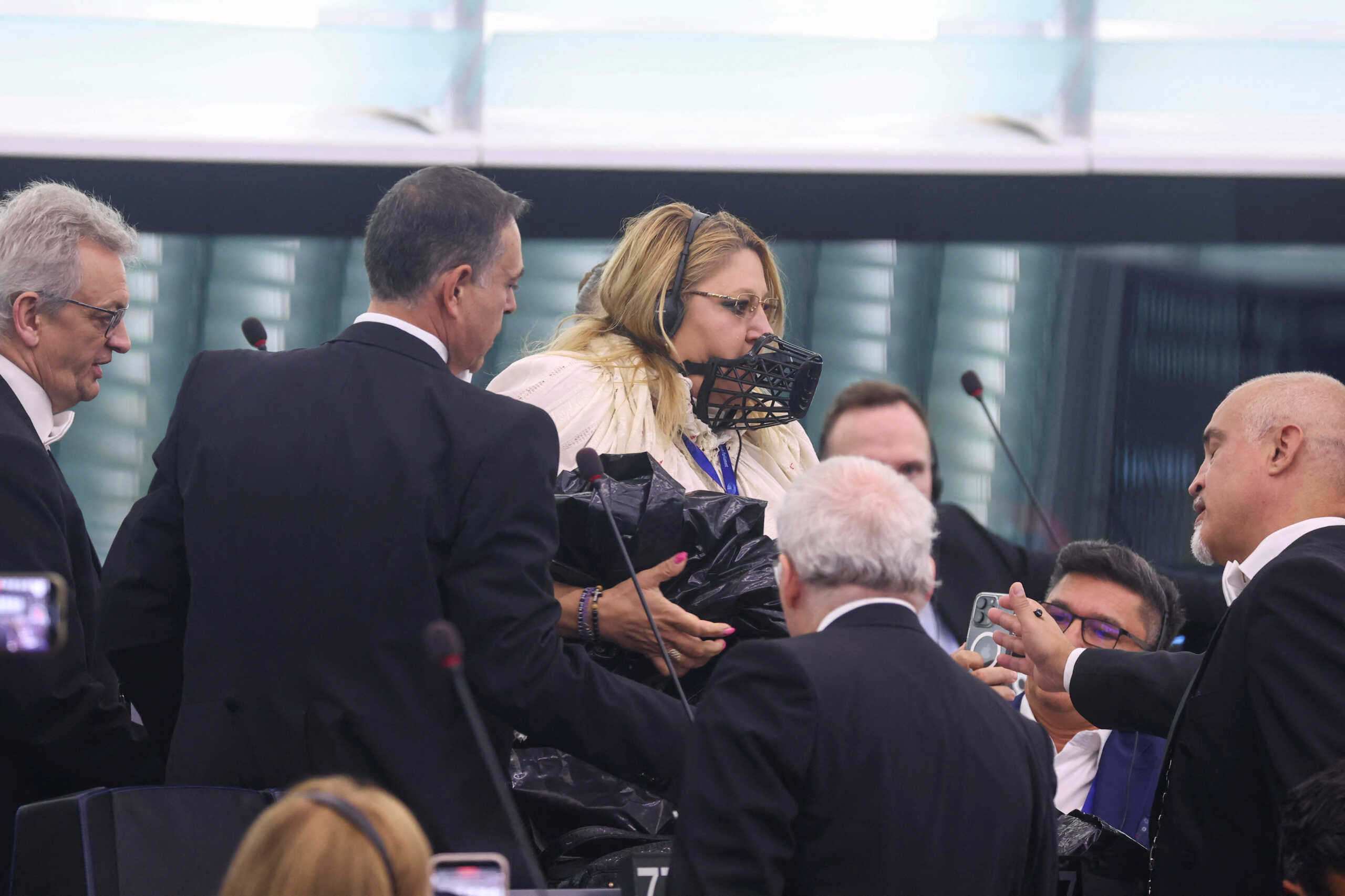 Ρουμάνα ευρωβουλευτής με φίμωτρο έκανε χαμό στο ευρωκοινοβούλιο: Την έβγαλαν σηκωτή γιατί ζητούσε παπά να τους διαβάσει