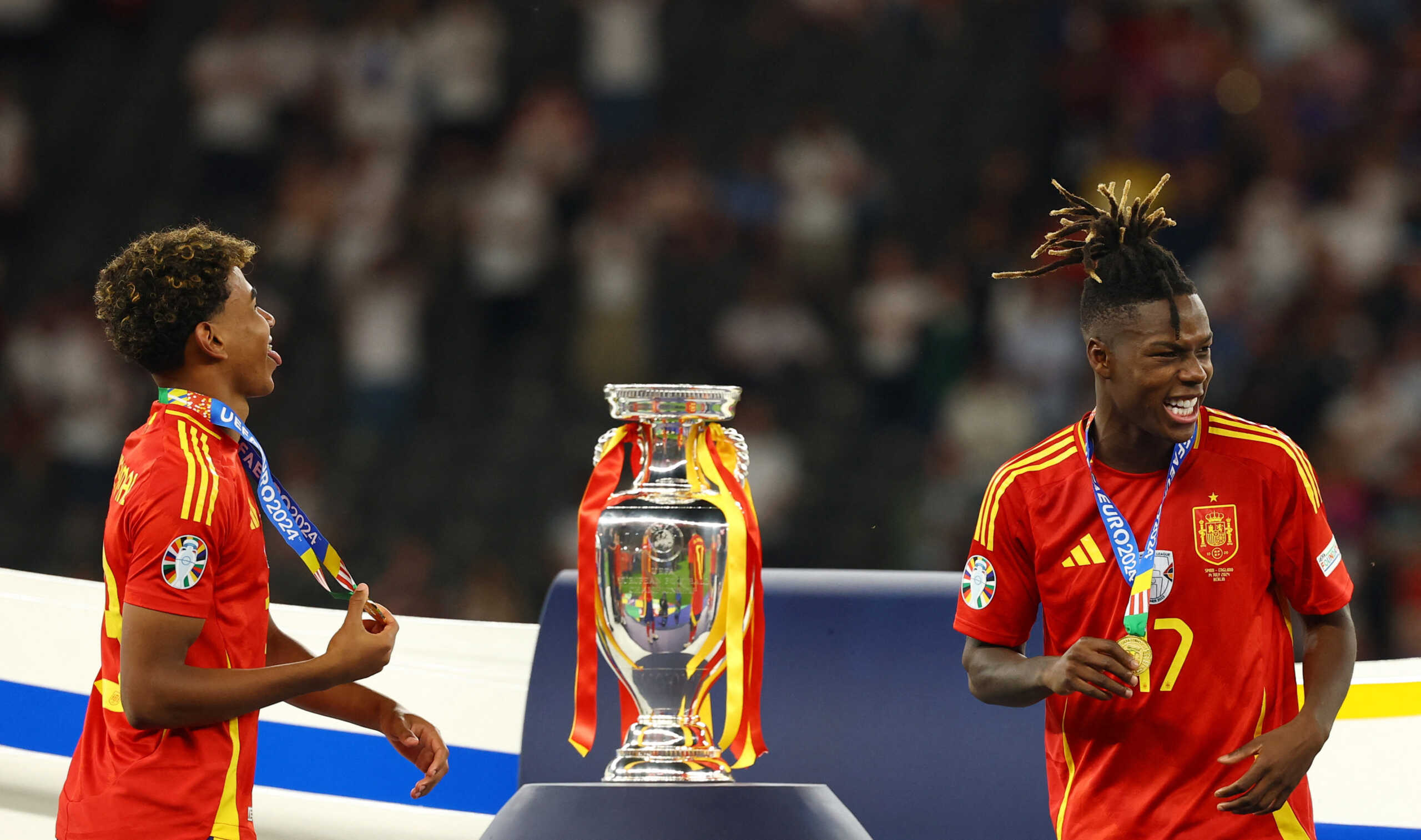 Soccer Football - Euro 2024 - Final - Spain v England - Berlin Olympiastadion, Berlin, Germany - July 14, 2024 Spain's Lamine Yamal and Nico Williams walk past the trophy after collecting their winners medals REUTERS