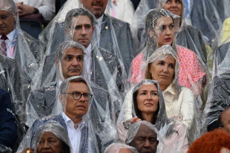 Ο Κυριάκος Μητσοτάκης και η Μαρέβα στην τελετή έναρξης των Ολυμπιακών Αγώνων με νάιλον λόγω της βροχής