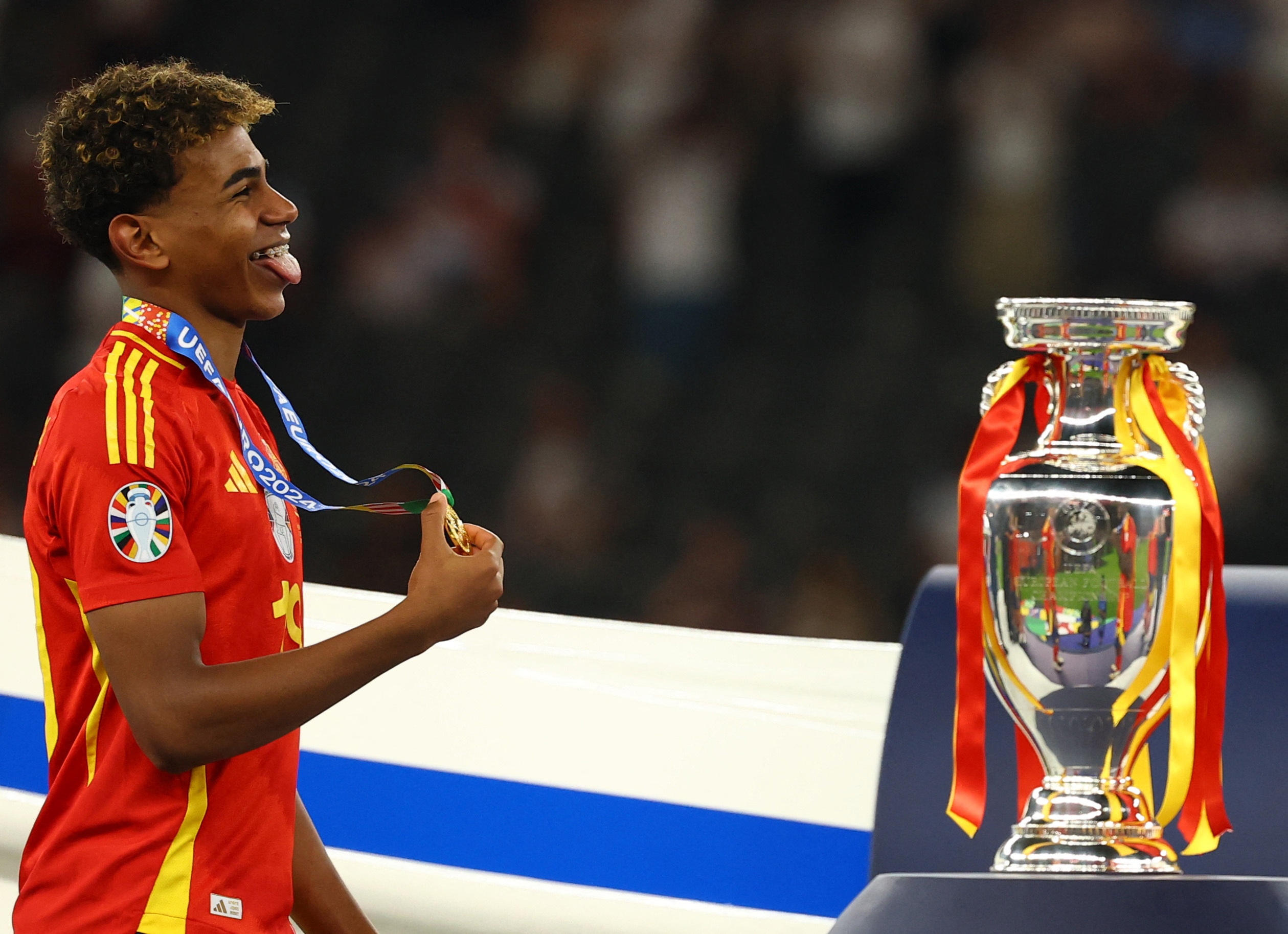 Soccer Football - Euro 2024 - Final - Spain v England - Berlin Olympiastadion, Berlin, Germany - July 14, 2024 Spain's Lamine Yamal walks past the trophy after collecting his winners medal REUTERS