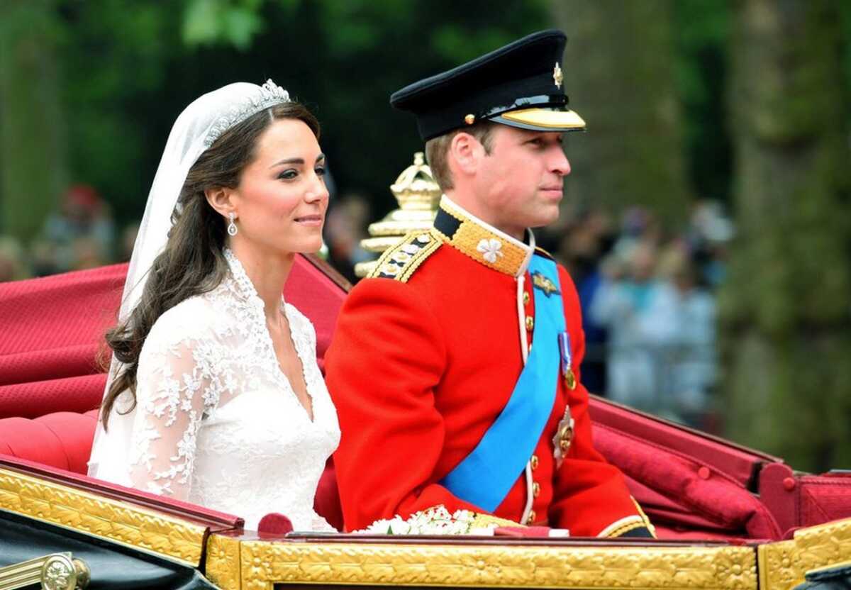 epa02708096 Prince William, Duke of Cambridge, (R) and his wife Catherine Middleton, Duchess of Cambridge (L) ride in a horse-drawn carriage from Westminster Abbey to Buckingham Palace escorted by a Captain's Escort of The Household Cavalry, in London, Britain, 29 April 2011, after their wedding ceremony. The newly-wed couple travels in the 1902 State Landau carriage which was built for King Edward VII for his coronation. The bride wears a v-neck Alexander McQueen gown, designed by creative director Sarah Burton and a 1936 Cartier halo tiara lent to her by Queen Elizabeth. EPA/DANIEL DEME