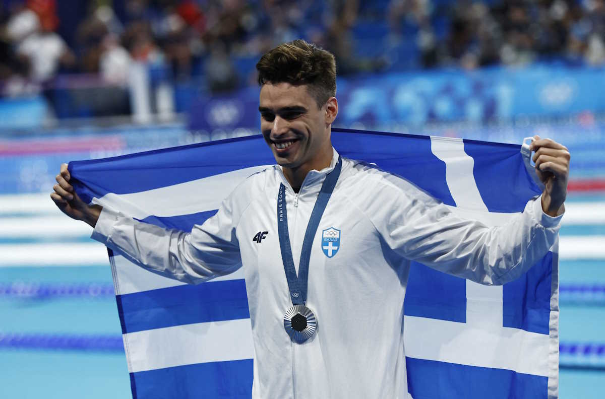 Paris 2024 Olympics - Swimming - Men's 200m Backstroke Victory Ceremony - Paris La Defense Arena, Nanterre, France - August 01, 2024. Silver medallist Apostolos Christou of Greece celebrates with his silver medal and the flag of Greece.