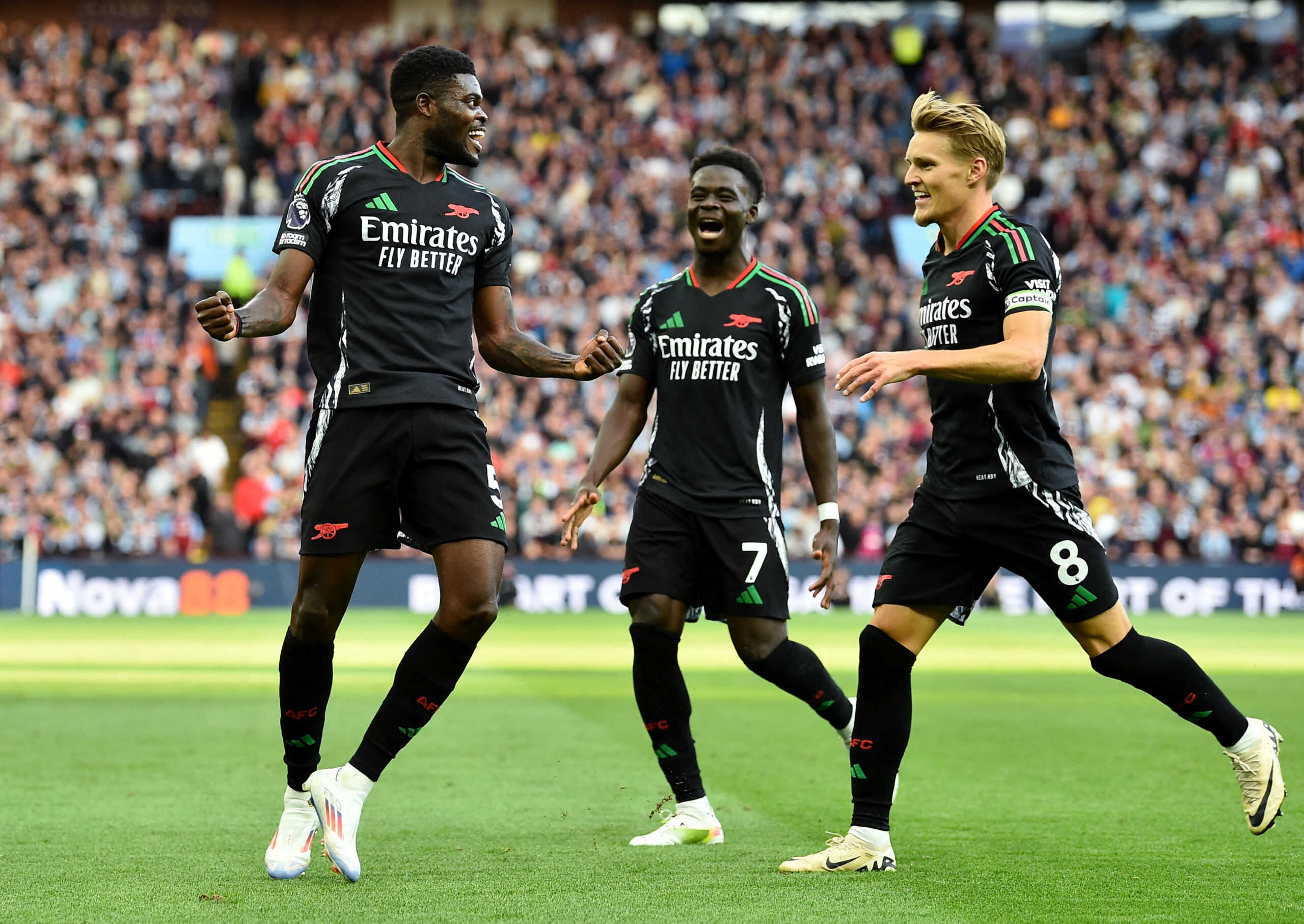 Soccer Football - Premier League - Aston Villa v Arsenal - Villa Park, Birmingham, Britain - August 24, 2024 Arsenal's Thomas Partey celebrates scoring their second goal with Bukayo Saka and Martin Odegaard REUTERS