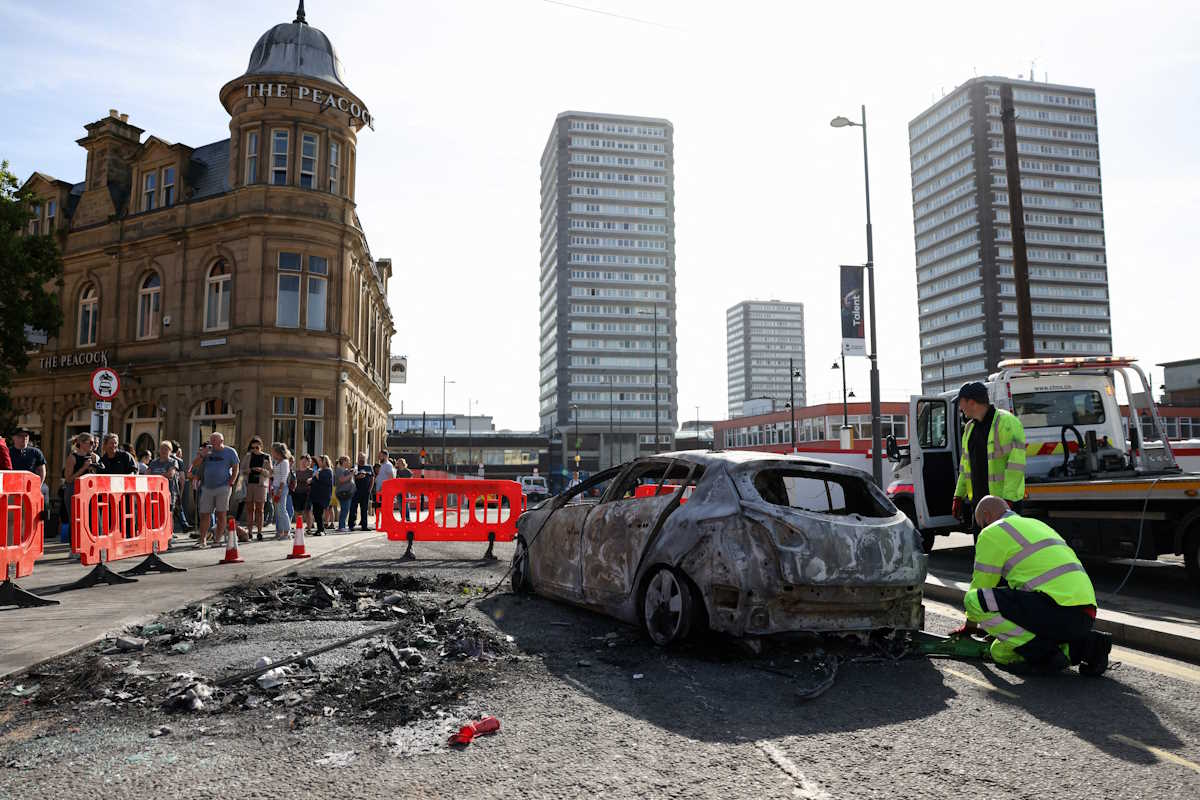 A burnt car is removed after a night of violent anti-immigrant demonstrations, in Sunderland, Britain, August 3, 2024. REUTERS