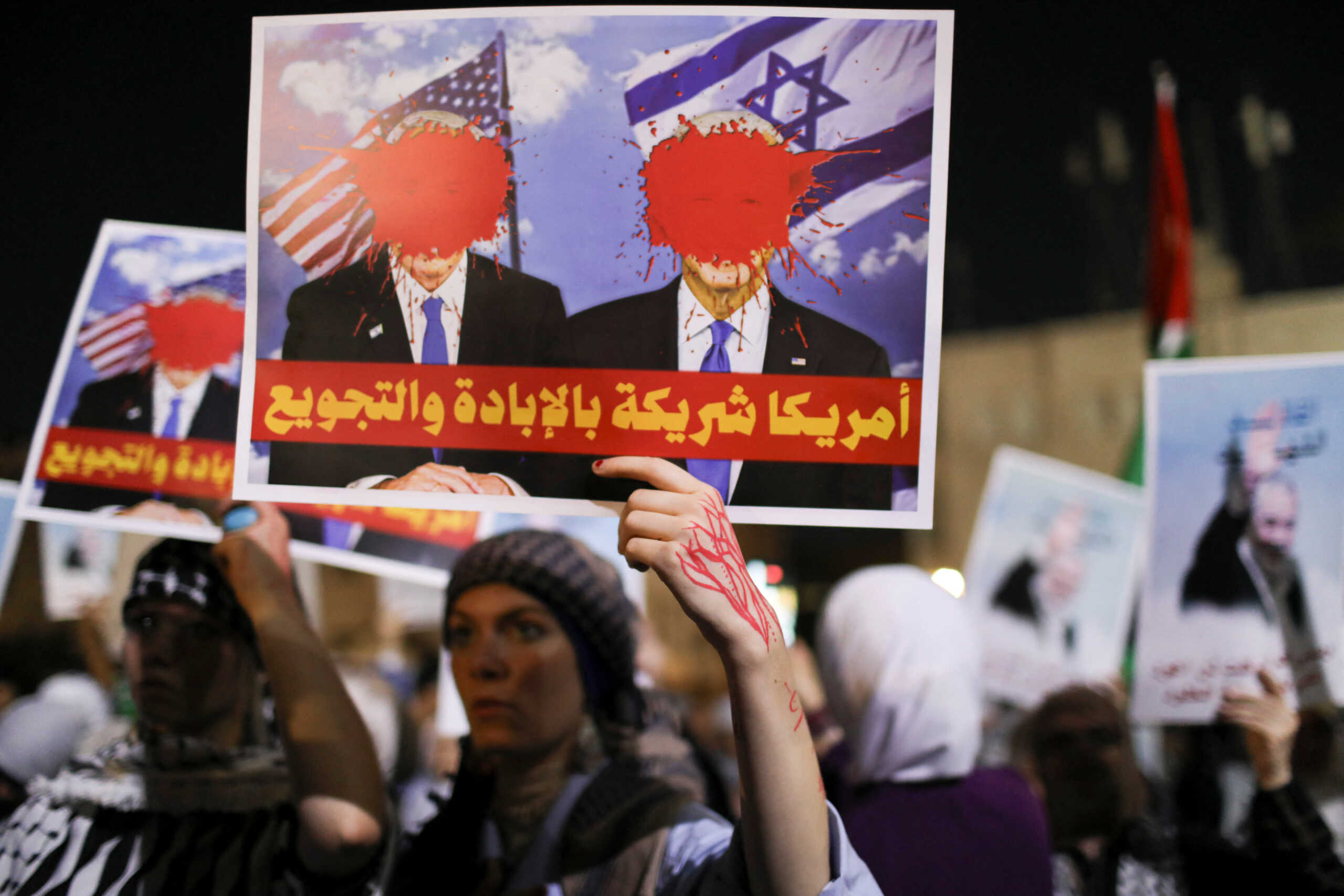 Demonstrators carry signs during a protest over the killing of Hamas leader Ismail Haniyeh in Iran and in support of Palestinians in Gaza, near the Israeli embassy in Amman, Jordan August 2, 2024. REUTERS