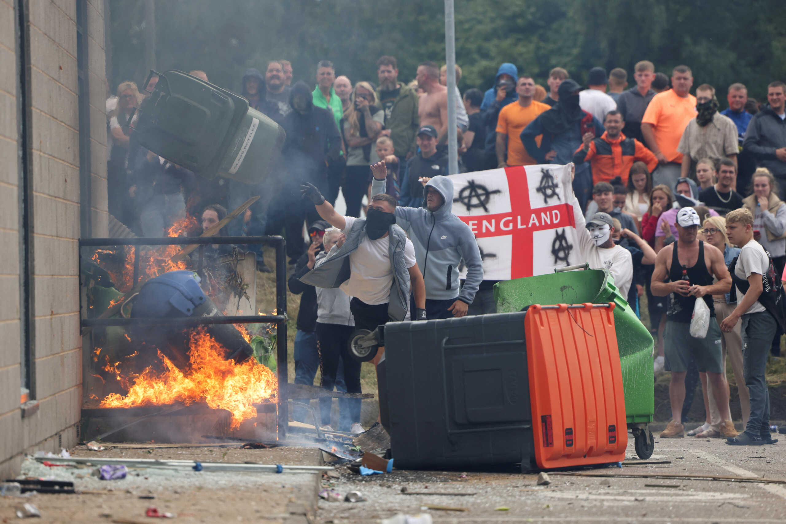 Demonstrators toss a trash bin during an anti-immigration protest, in Rotherham, Britain, August 4, 2024. REUTERS