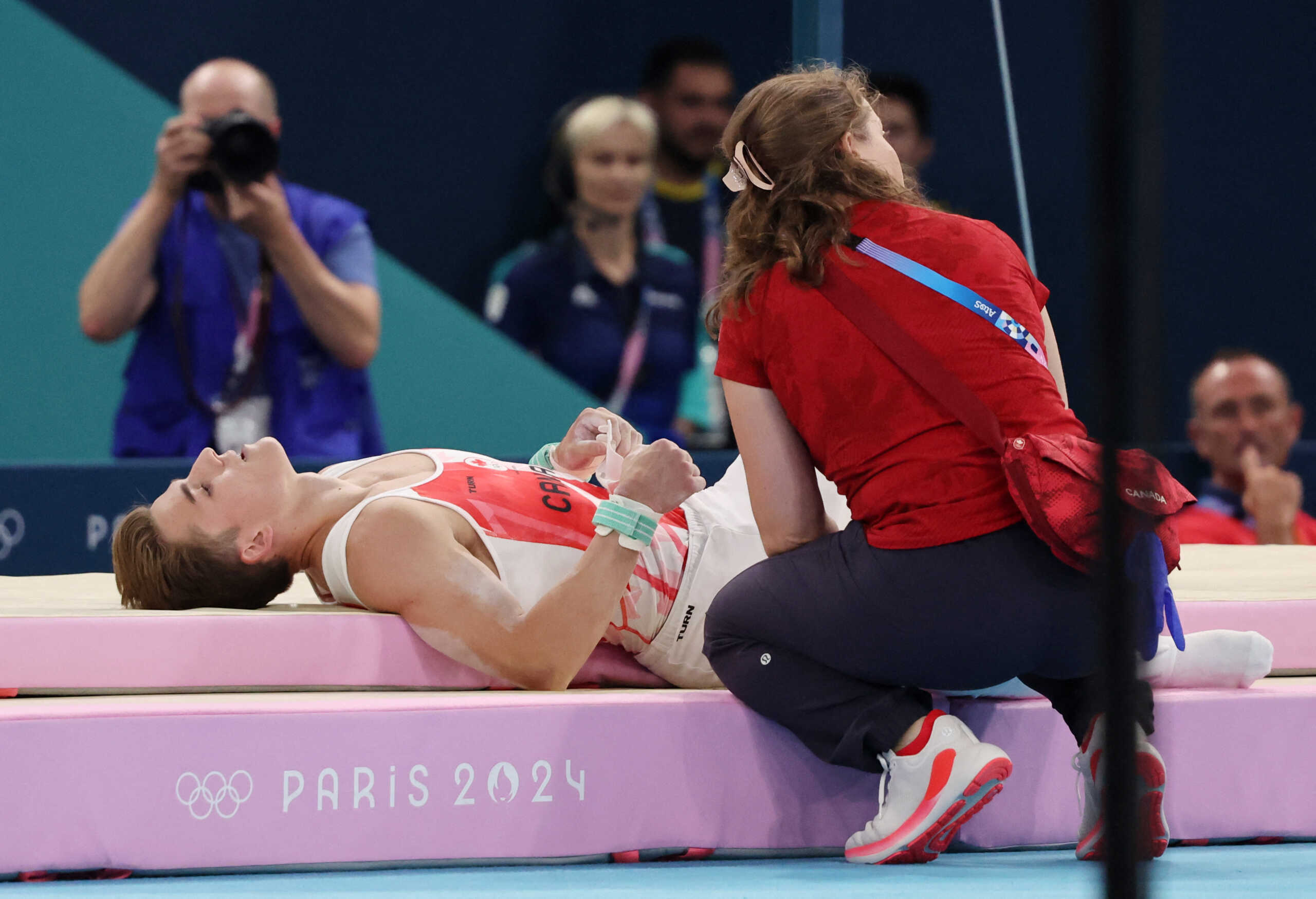 Paris 2024 Olympics - Artistic Gymnastics - Men's All-Around Final - Bercy Arena, Paris, France - July 31, 2024. Felix Dolci of Canada receives medical attention after falling on the Horizontal Bar. REUTERS