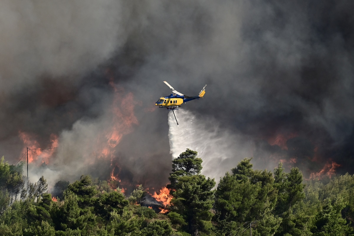 A firefighting helicopter makes a water drop as a wildfire burns in Varnava, near Athens, Greece, August 11, 2024. Michalis Karagiannis