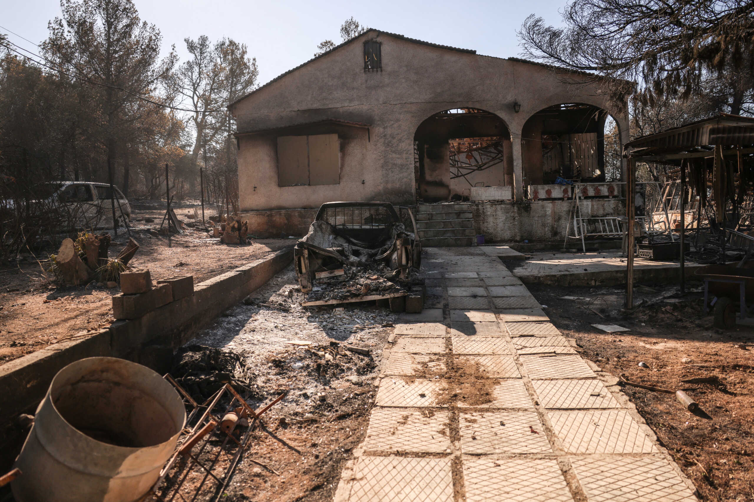 A view of a burned out house and cars following the wildfire in Halandri suburb in Athens, Greece,  August 13, 2024. REUTERS