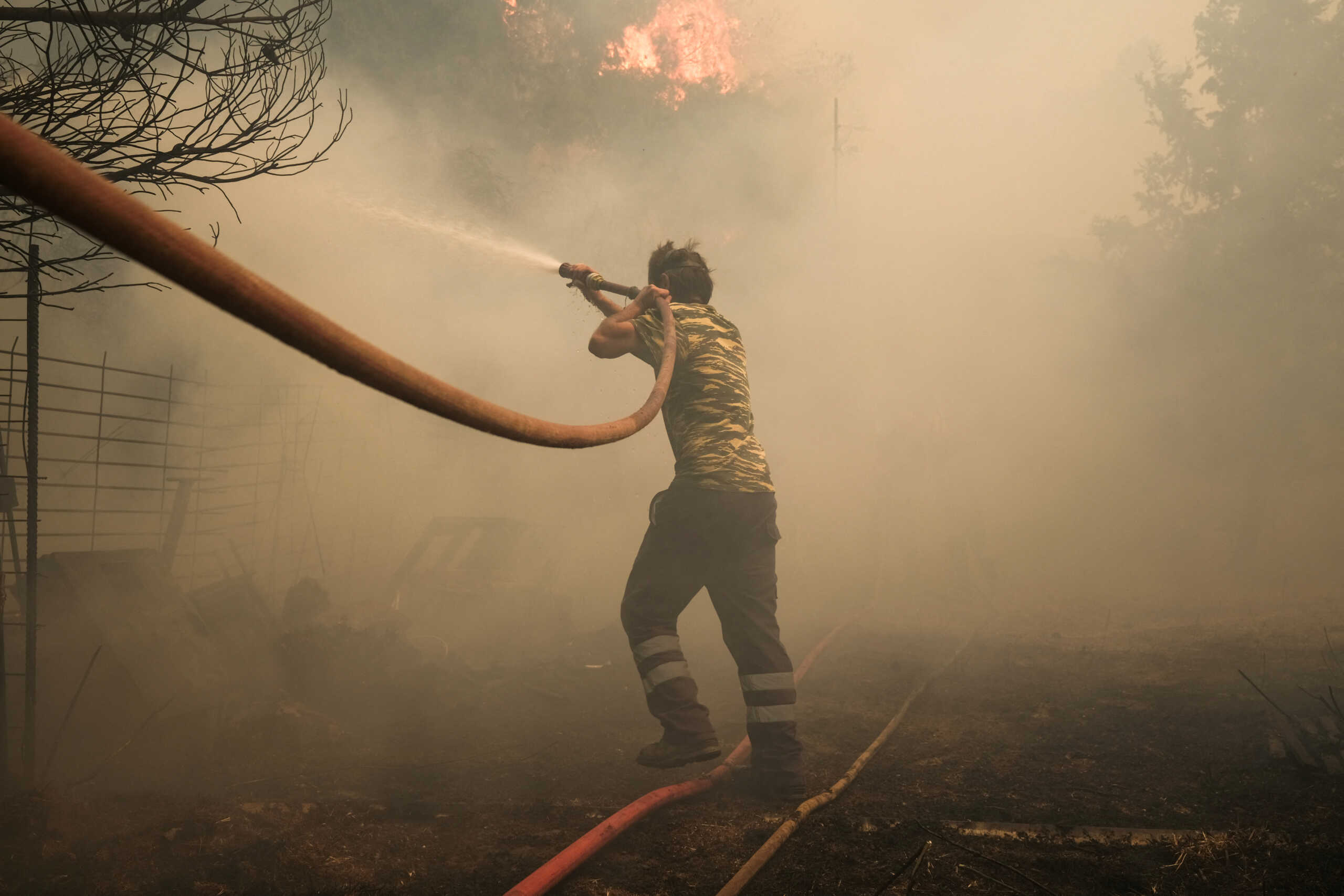 A volunteer tries to extinguish a wildfire burning in Nea Penteli, Greece, August 12, 2024. REUTERS