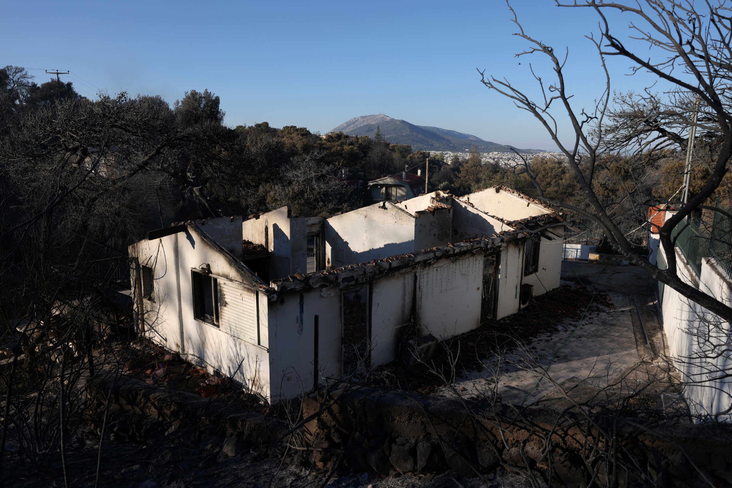 Burned houses are seen following a wildfire in the Penteli area near Athens, Greece, August 13, 2024. REUTERS