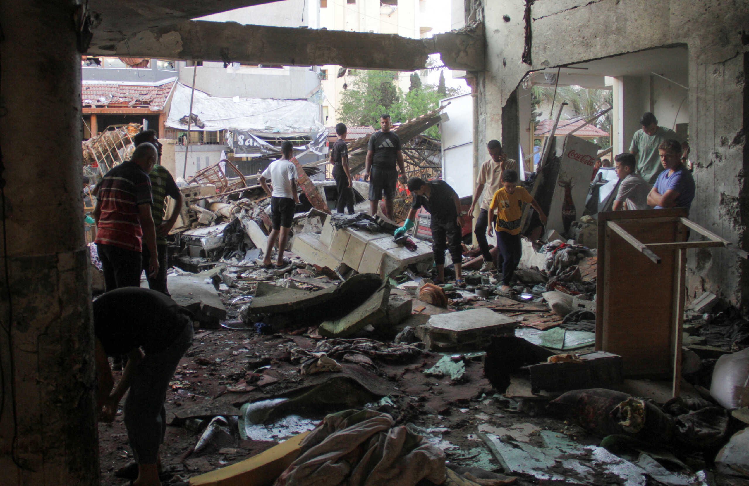 Palestinians look at the damage at the site of an Israeli strike on a school sheltering displaced people, amid the Israel-Hamas conflict, in Gaza City August 10, 2024. REUTERS