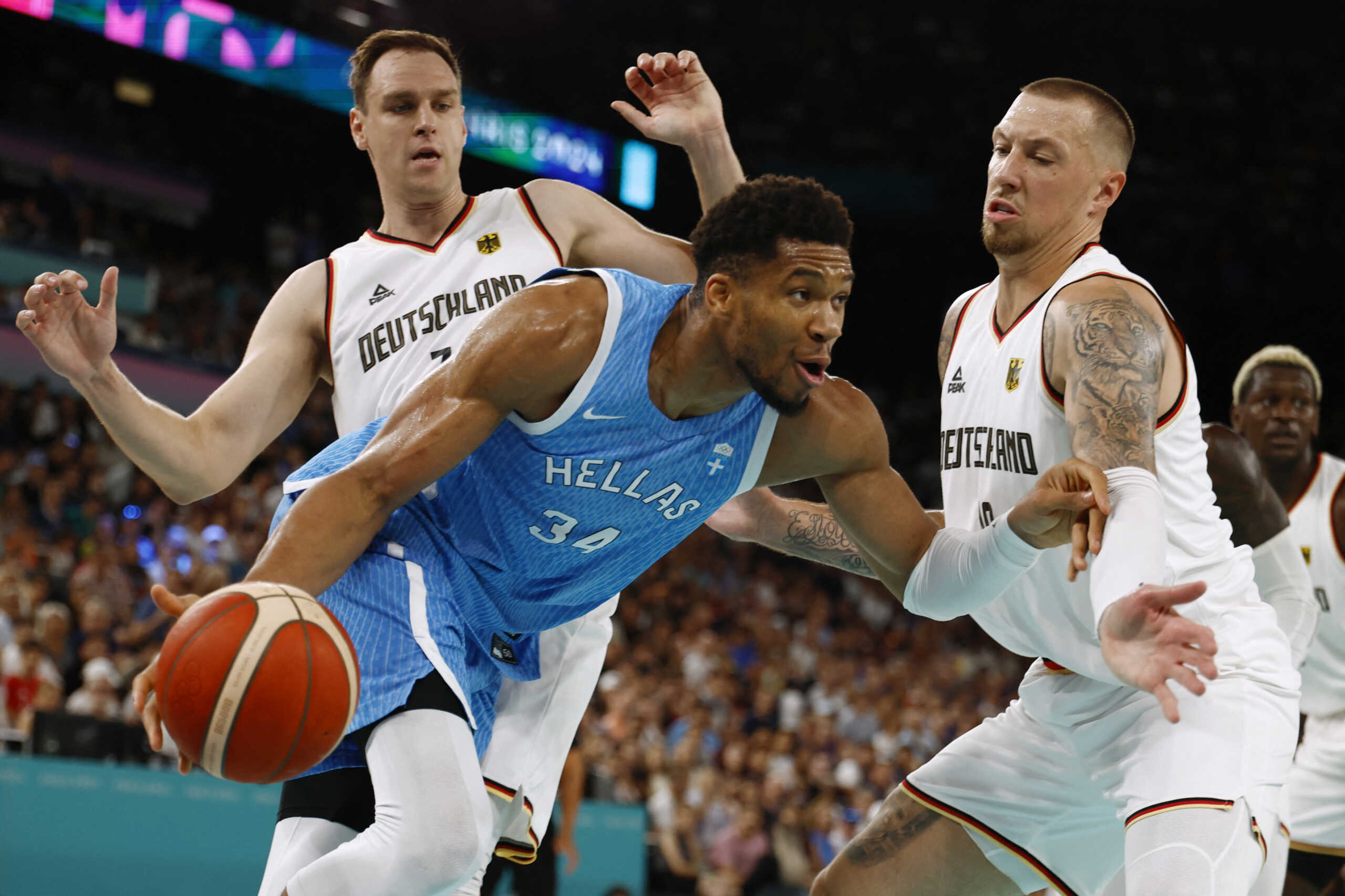 Paris 2024 Olympics - Basketball - Men's Quarterfinal- Germany vs Greece - Bercy Arena, Paris, France - August 06, 2024. Giannis Antetokounmpo of Greece in action against Johannes Voigtmann of Germany and Daniel Theis of Germany REUTERS