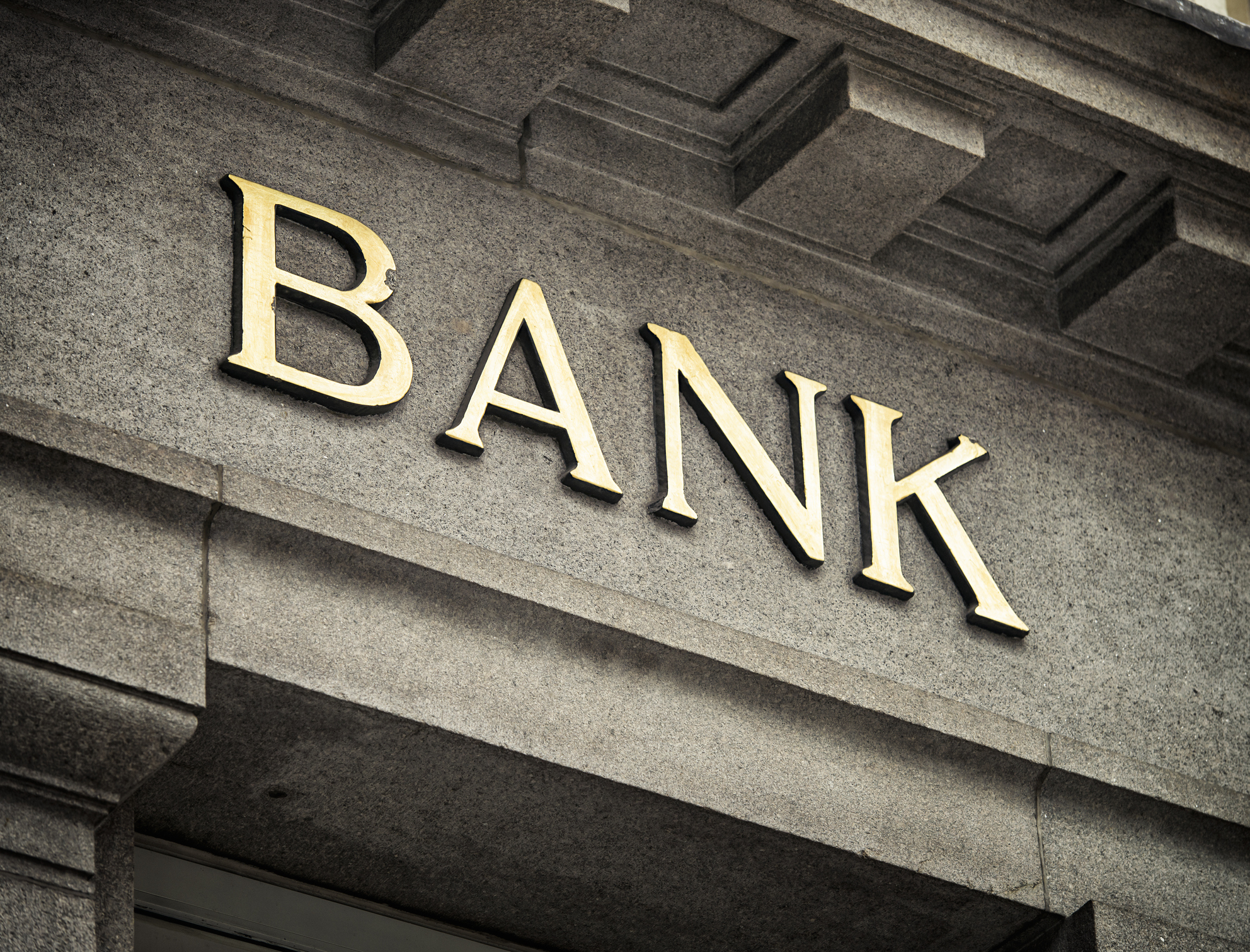 An old fashioned 'Bank' sign on a building exterior.