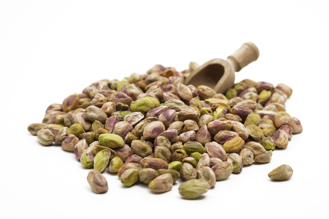 close-up of salted pistachios without shells on white background