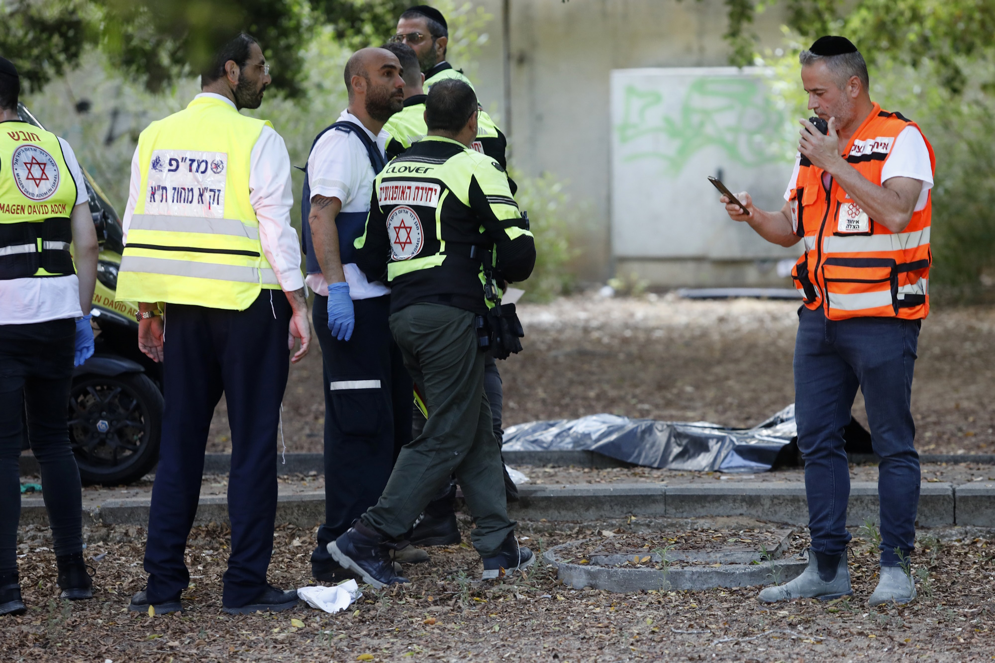 First responders work at the site of a stabbing attack that, Israeli police said, a Palestinian attacked killed a woman and wounded a few others in Holon, Israel Sunday, Aug. 4, 2024.(AP Photo