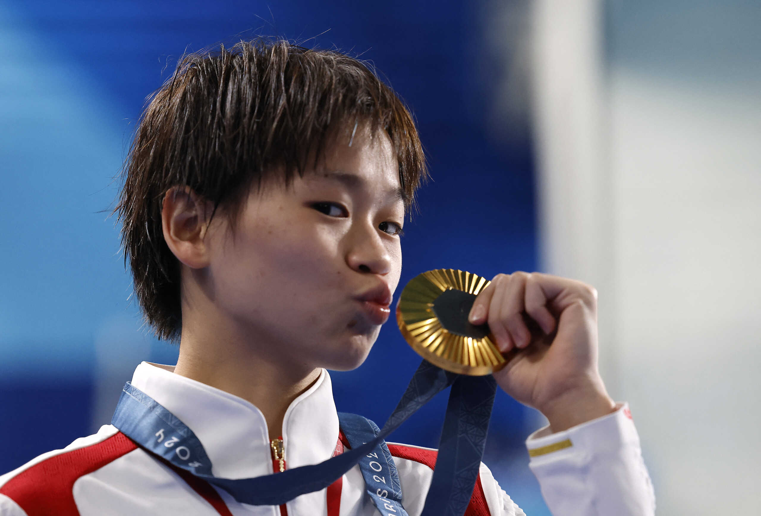 Paris 2024 Olympics - Diving - Women's 10m Platform Victory Ceremony - Aquatics Centre, Saint-Denis, France - August 06, 2024. Gold medallist Hongchan Quan of China celebrates with her medal on the podium. REUTERS