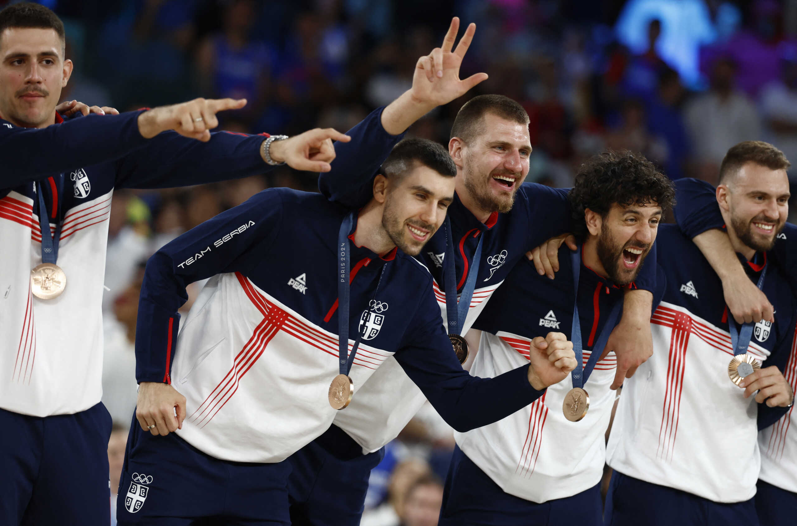 Paris 2024 Olympics - Basketball - Men's Victory Ceremony - Bercy Arena, Paris, France - August 10, 2024. Bronze medallists Vanja Marinkovic of Serbia, Ognjen Dobric of Serbia, Nikola Jokic of Serbia, Vasilije Micic of Serbia, and Marko Guduric of Serbia celebrate on the podium. REUTERS