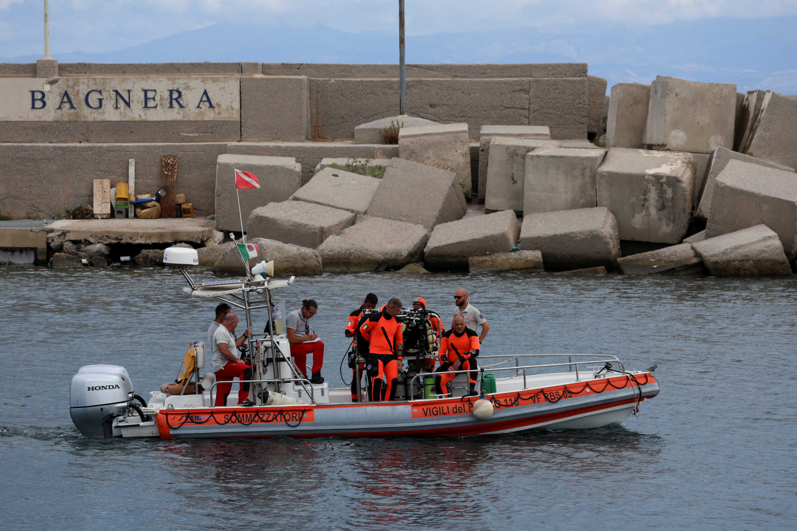 Rescue personnel operate at a port to search for the missing, including British entrepreneur Mike Lynch, after a luxury yacht sank off the coast of Porticello, near the Sicilian city of Palermo, Italy, August 21, 2024. REUTERS