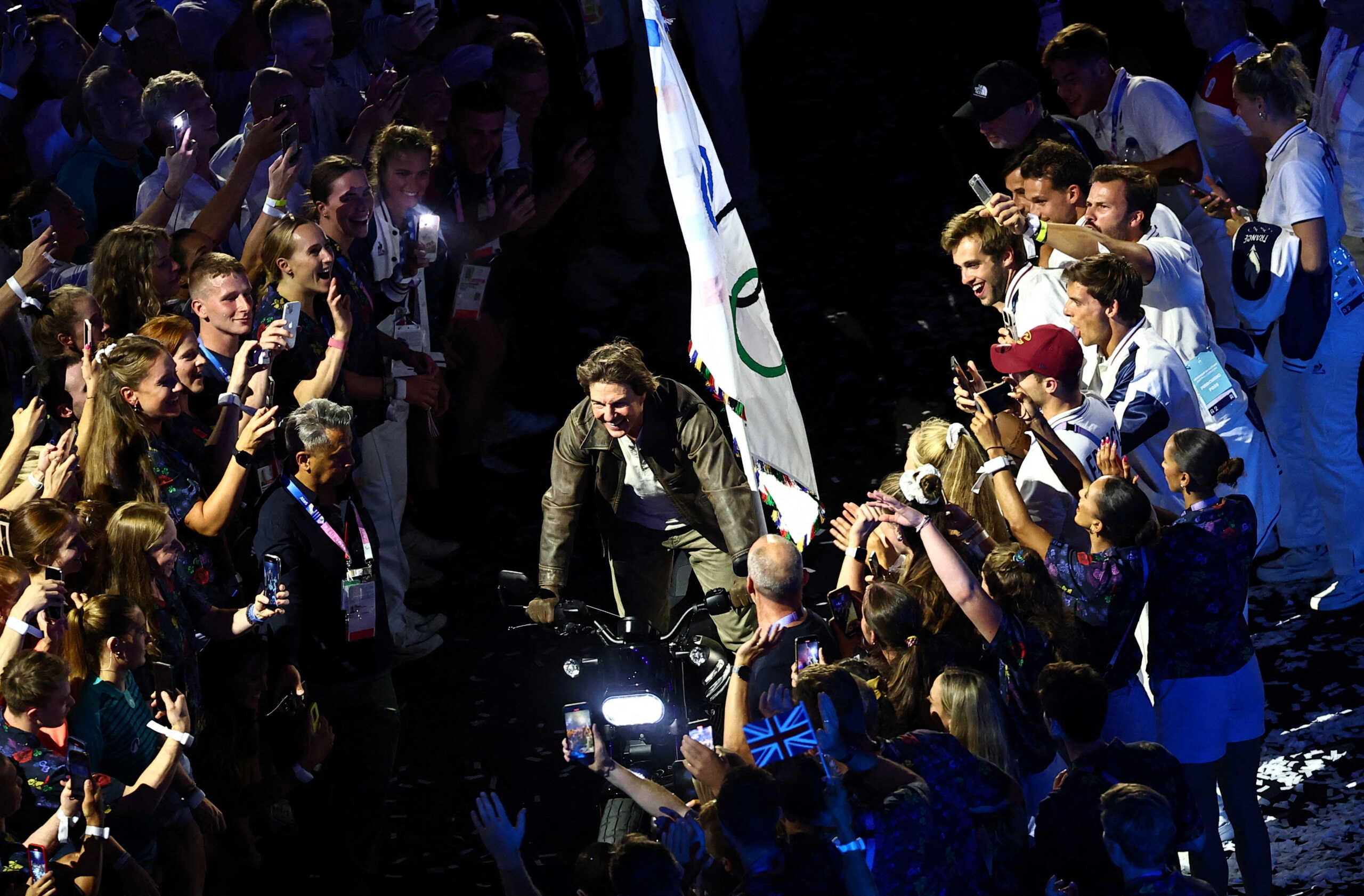 Paris 2024 Olympics - Ceremonies - Paris 2024 Closing Ceremony - Stade de France, Saint-Denis, France - August 11, 2024. Actor Tom Cruise rides a motorbike with the Olympics flag among athletes during the closing ceremony. REUTERS