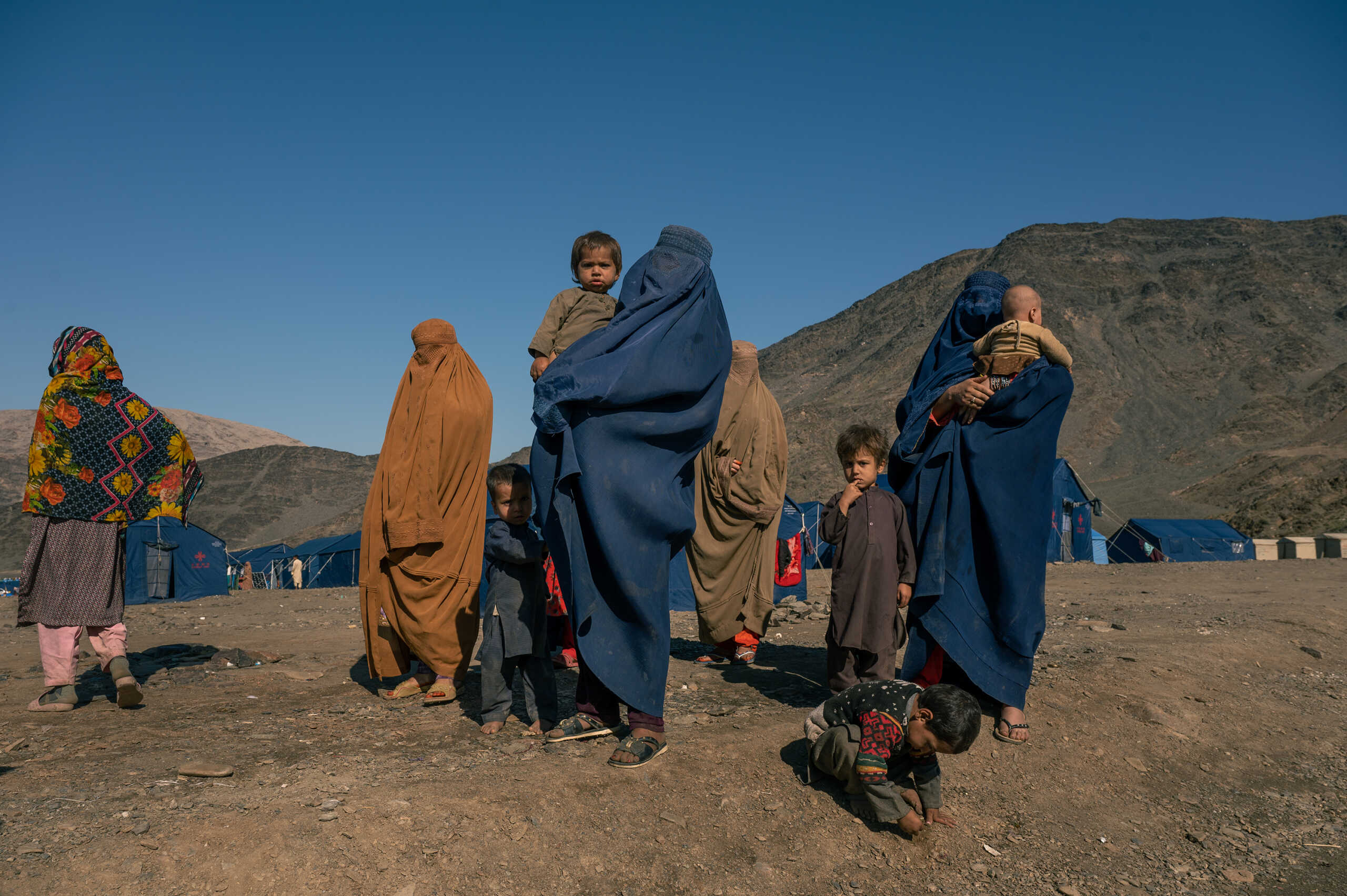 TORKHAM - NOVEMBER 10: Returnees women and their children stand in a humanitarian camp set near the Torkham border crossing in Eastern Afghanistan, for returnees who have been deported or coerced into leaving Pakistan, on November 10, 2023. Out of 1.4 millions Afghans living illegally in Pakistan, 250,000 people have so far returned as part of Islamabad's massive deportation and repatriation campaignan effort that has led the Taliban to start managing a major humanitarian crisis, with camps, food distributions, bus services and more. (Photo by Elise Blanchard for The Washington Post via Getty Images)