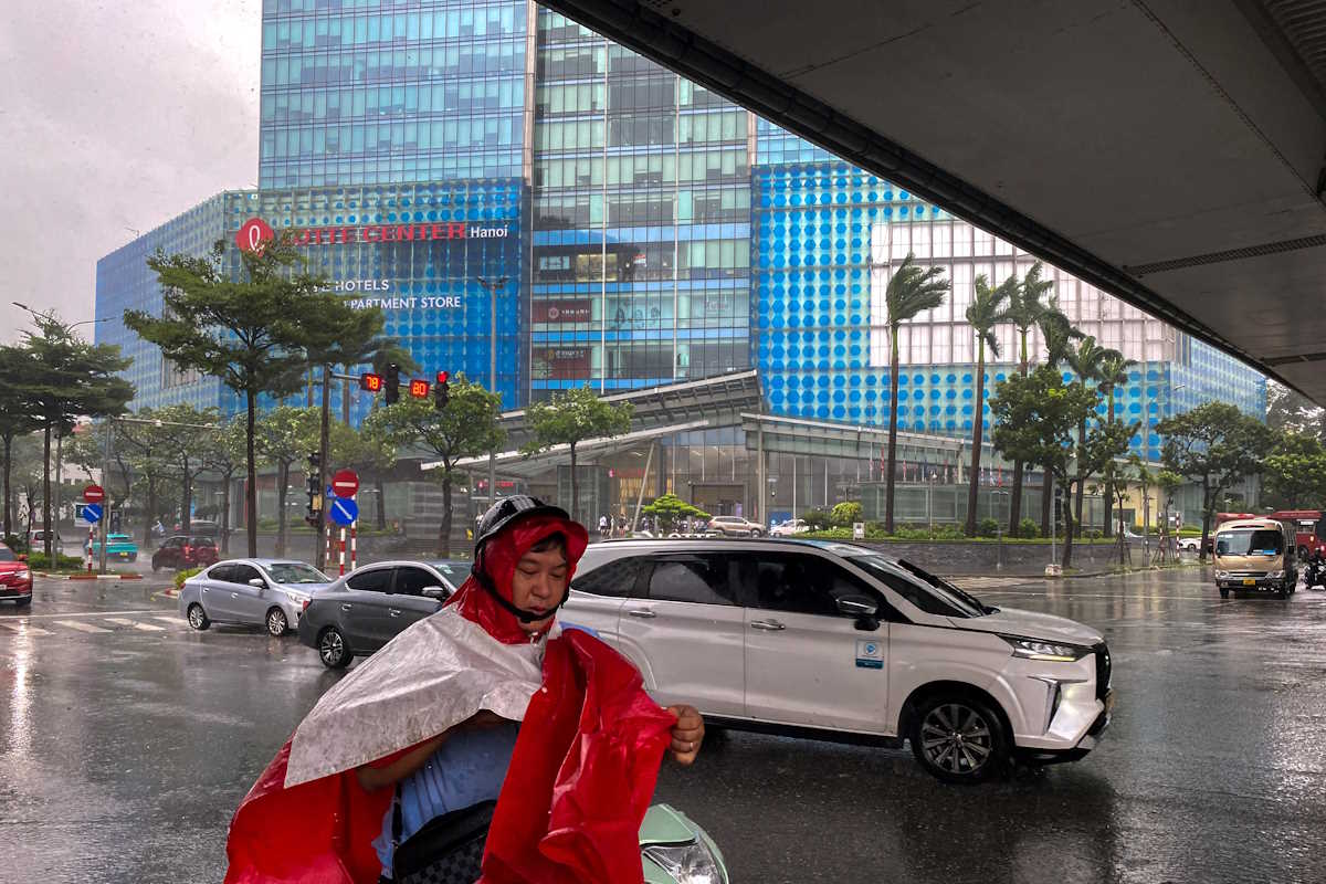 A man puts on waterproof clothing amid the impact of Typhoon Yagi, in Hanoi, Vietnam, September 7, 2024. REUTERS