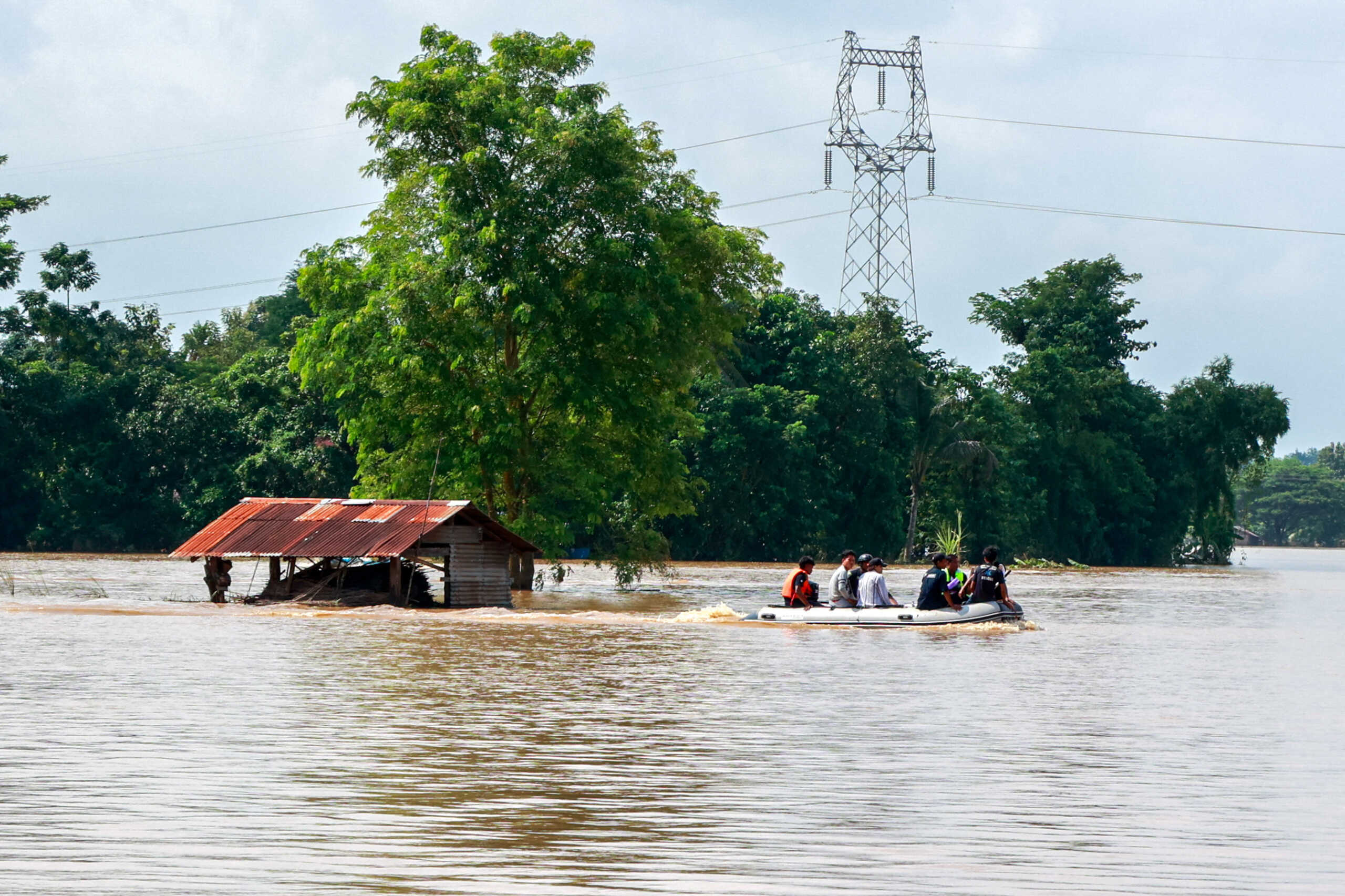 Volunteers ride a boat through a flooded area, searching for stranded people following the impact of Typhoon Yagi in Taungnoo city, Myanmar, September 17, 2024. REUTERS