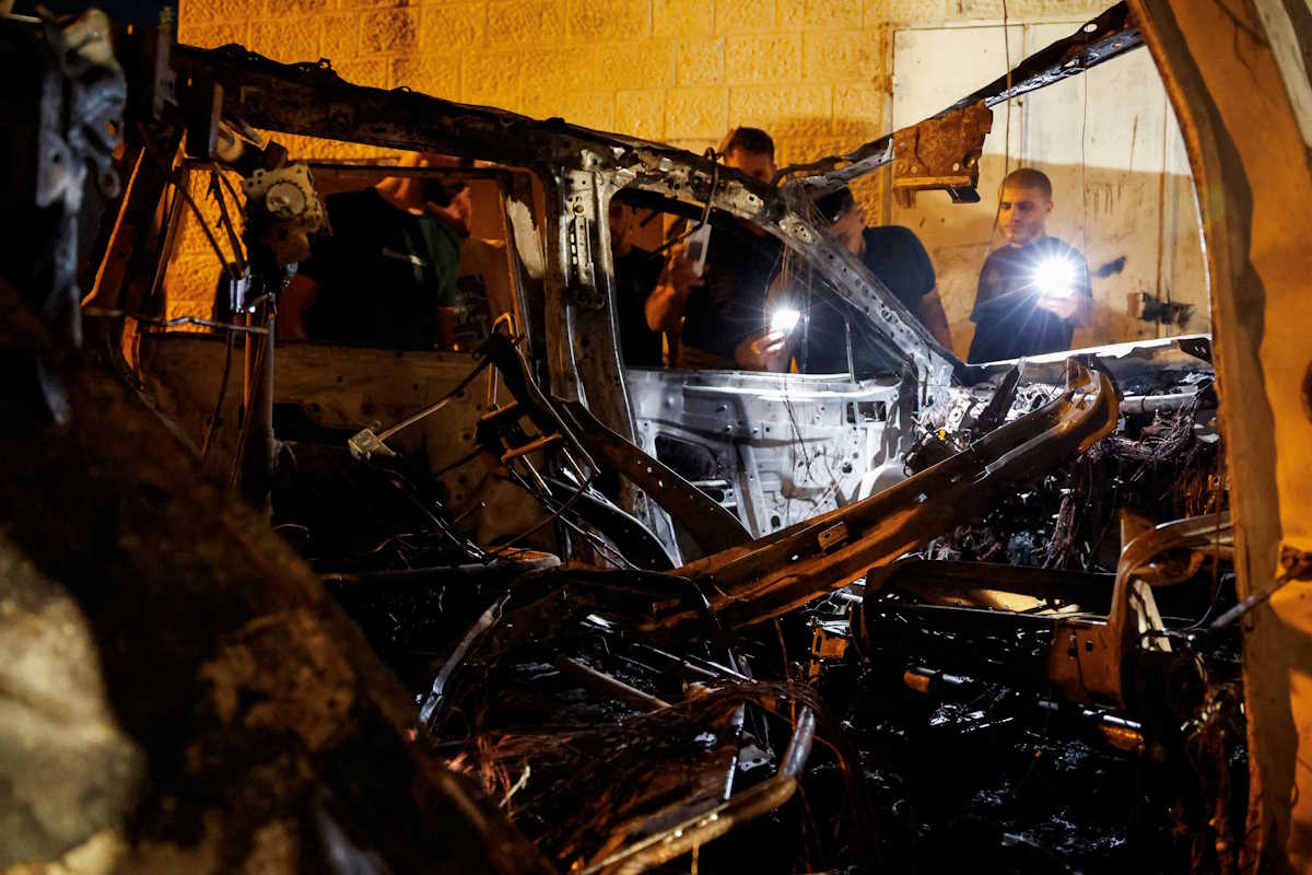 Palestinians inspect a car that was destroyed in an Israeli airstrike, in Qabatya, near Jenin, in the Israeli-occupied West Bank, September 19, 2024. REUTERS