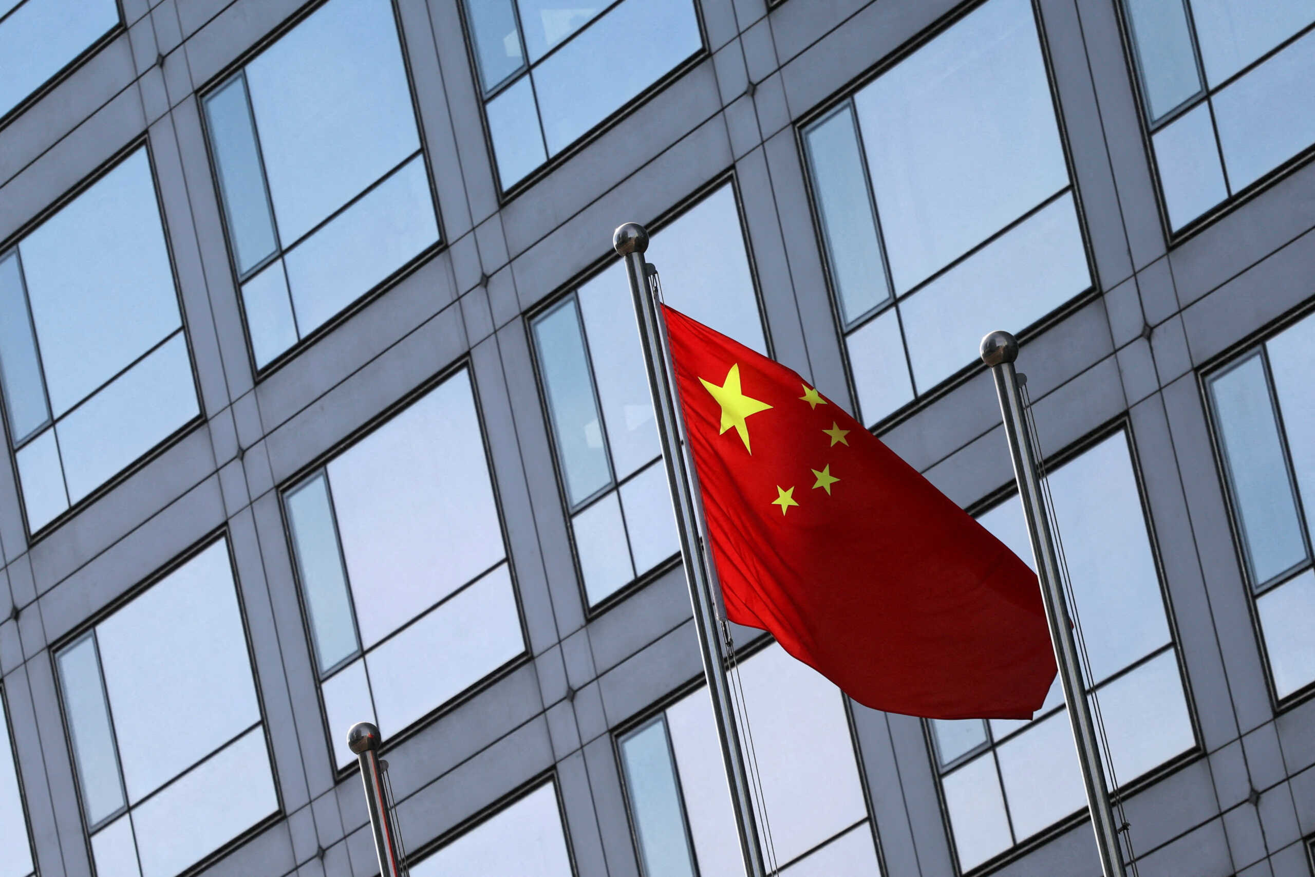 FILE PHOTO: A Chinese flag flutters outside the China Securities Regulatory Commission (CSRC) building on the Financial Street in Beijing, China February 8, 2024. REUTERS