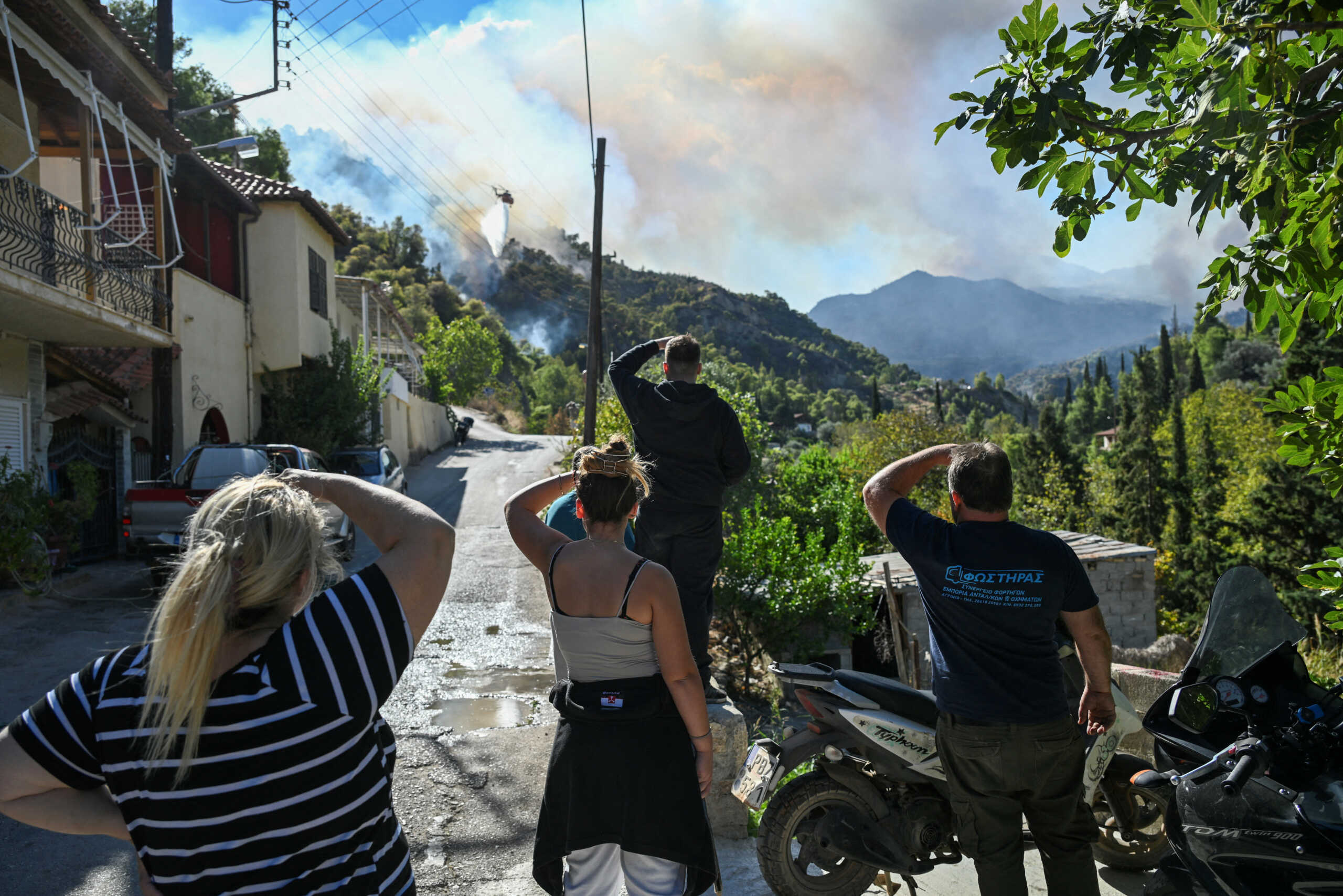 Locals watch a wildfire burning near the village of Helidori, near Corinth, Greece, September 30, 2024. REUTERS