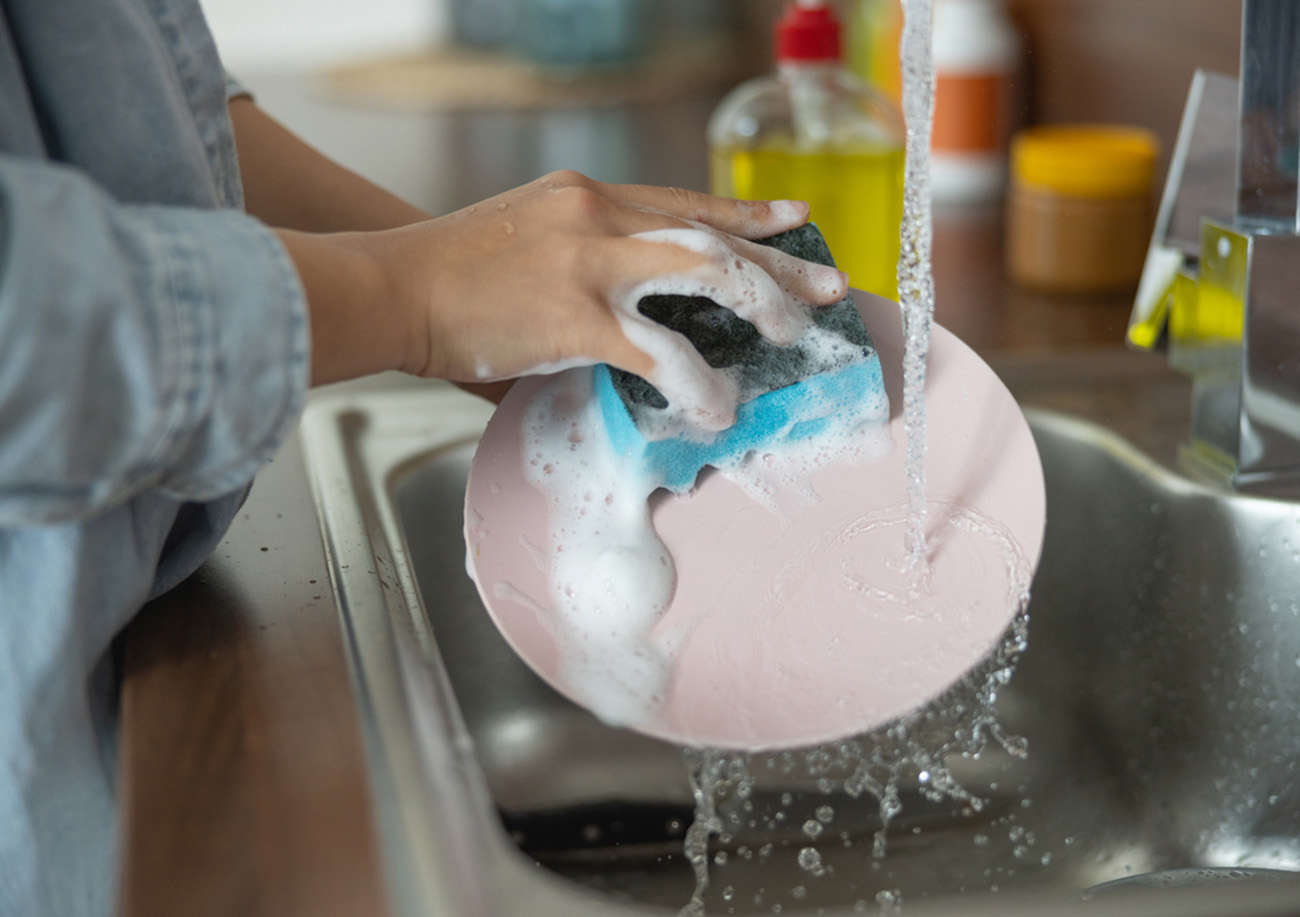 Close up of female hands cleaning a dirty plate