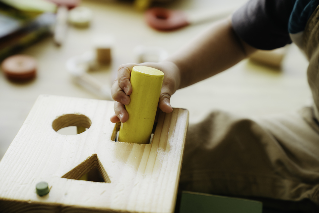 A baby is playing with a wooden toy block