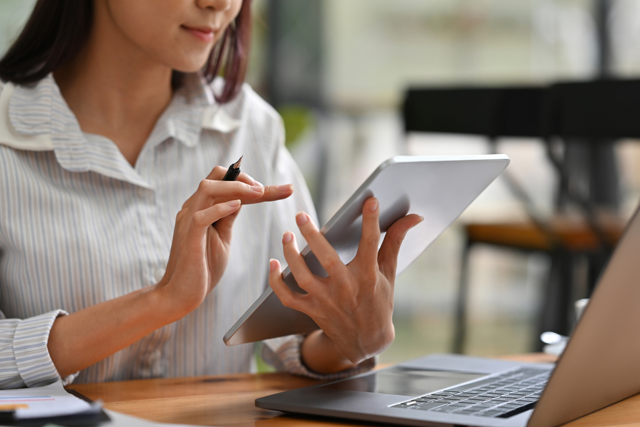 Close up or cropped image of Business and financial woman using tablet and laptop for working.