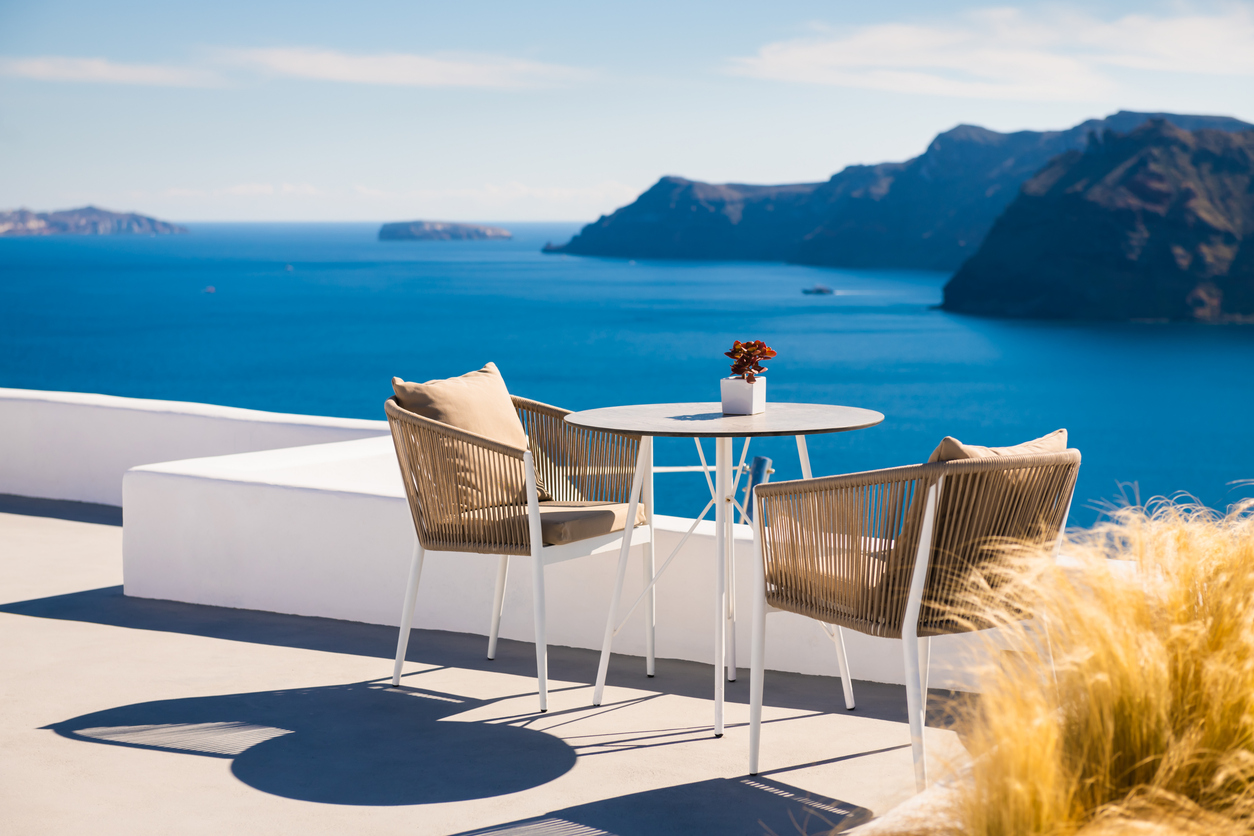 White architecture in Santorini island, Greece. Two chairs on the terrace with sea view. Travel and summer vacation concept