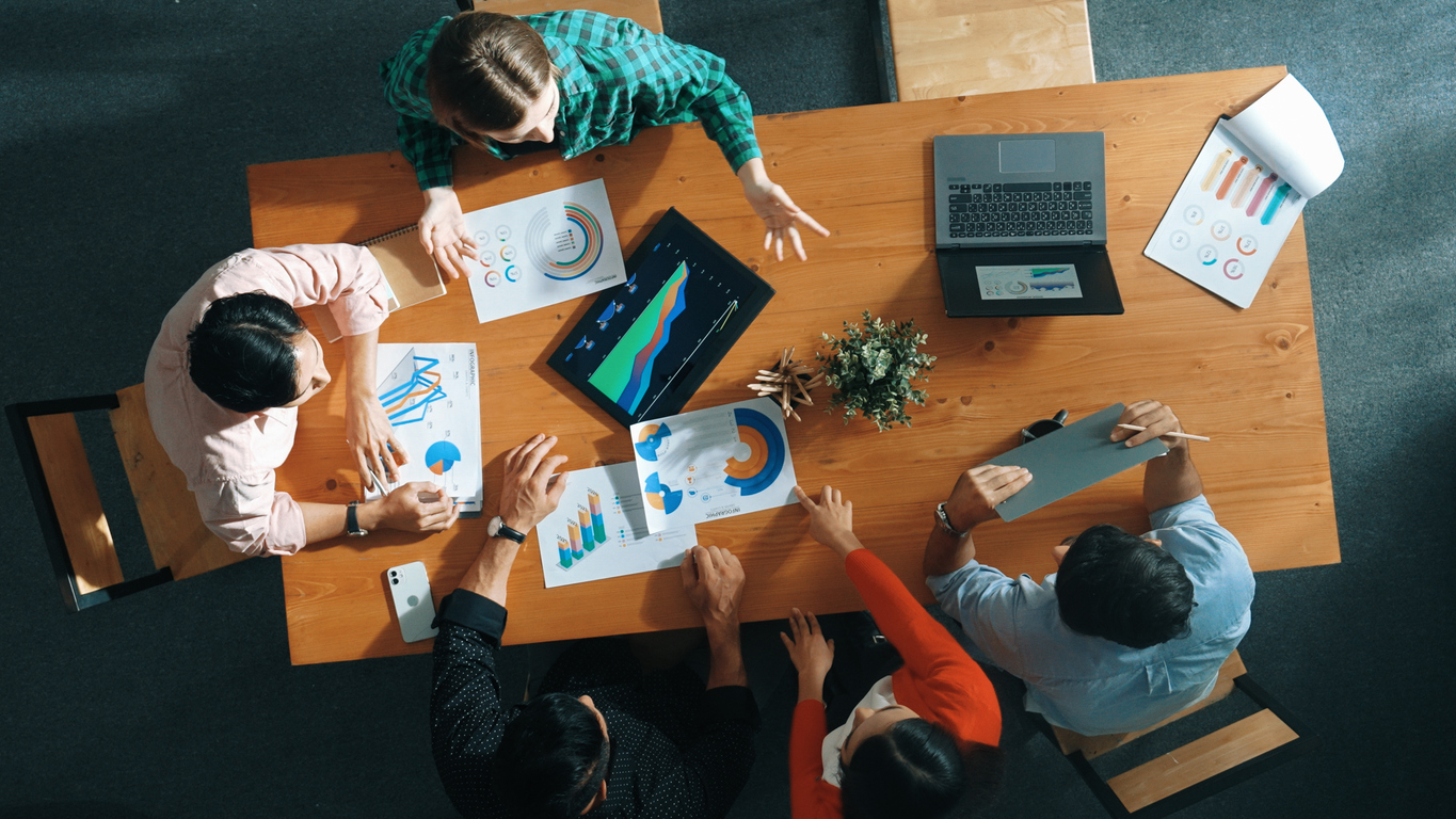 Top down view of business woman explain and present financial chart. Diverse group discuss and listen presentation about stock market statistic at meeting table with investment graph. Convocation.