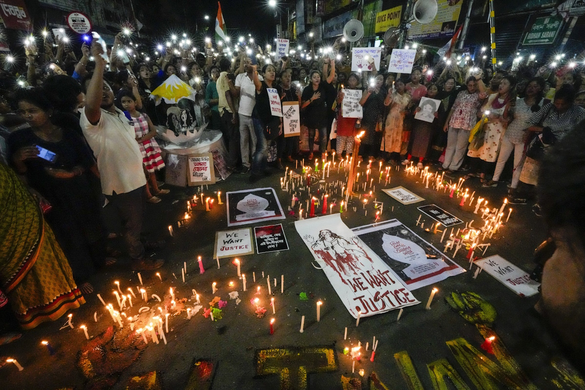 People hold lit mobile phones while surrounding candle lights and posters on road protesting against the rape and murder of a resident doctor at a government hospital in early August, in Kolkata, India, Wednesday, Sept. 4, 2024. (AP Photo