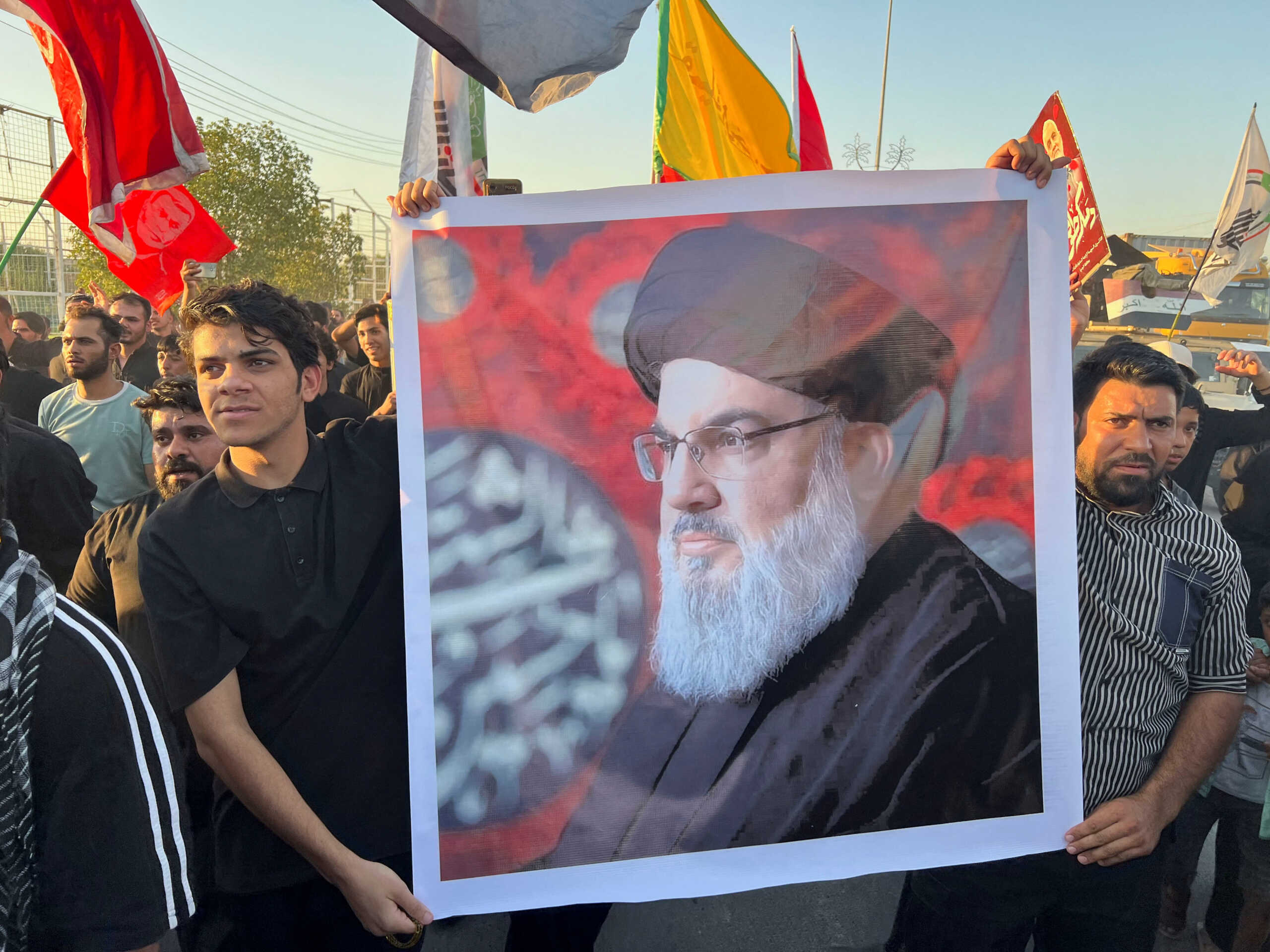 People hold a poster of Lebanon's Hezbollah leader Sayyed Hassan Nasrallah at a gathering, following the announcement of his death, in Basra, Iraq, September 28, 2024. REUTERS