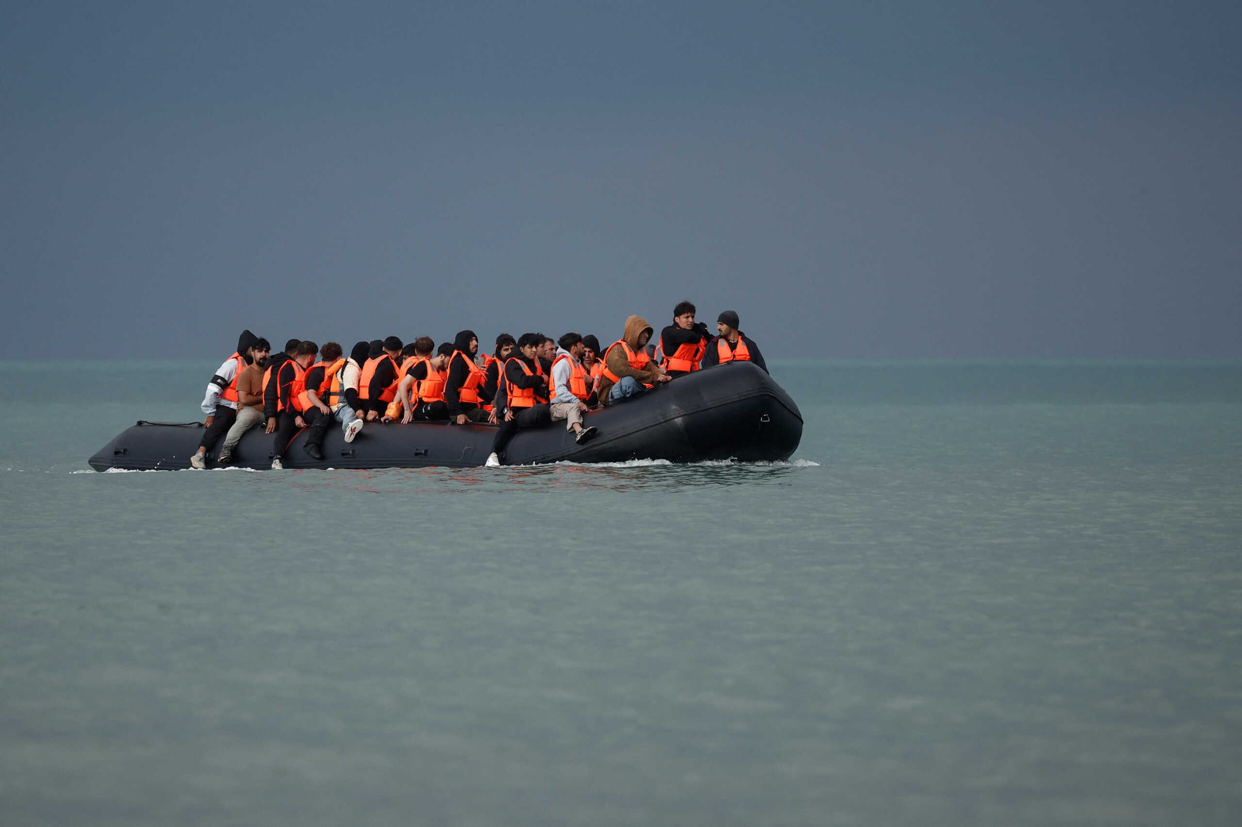 Migrants on an inflatable dinghy attempt to cross the English Channel to reach Britain, on the beach of the Slack dunes in Wimereux, France, September 4, 2024. REUTERS