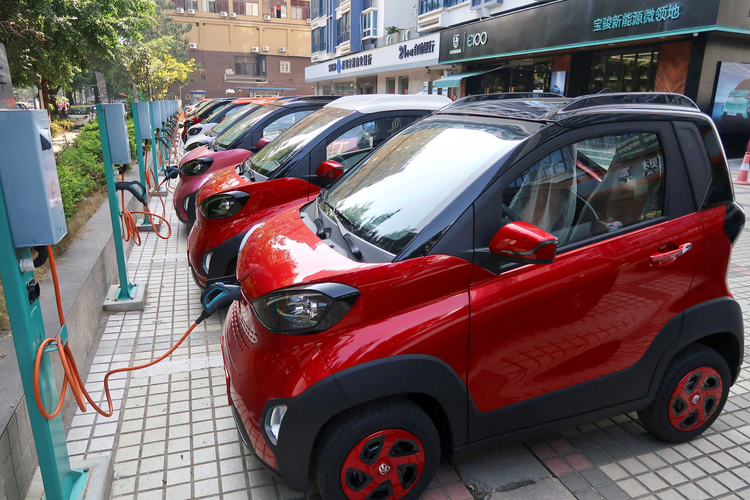 FILE PHOTO: Baojun E100 all-electric battery cars are seen while they are being charged in the parking lot in front of a Baojun NEV Experience Center store in Liuzhou, Guangxi Zhuang Autonomous Region, China, November 8, 2017. Picture taken November 8, 2017. REUTERS