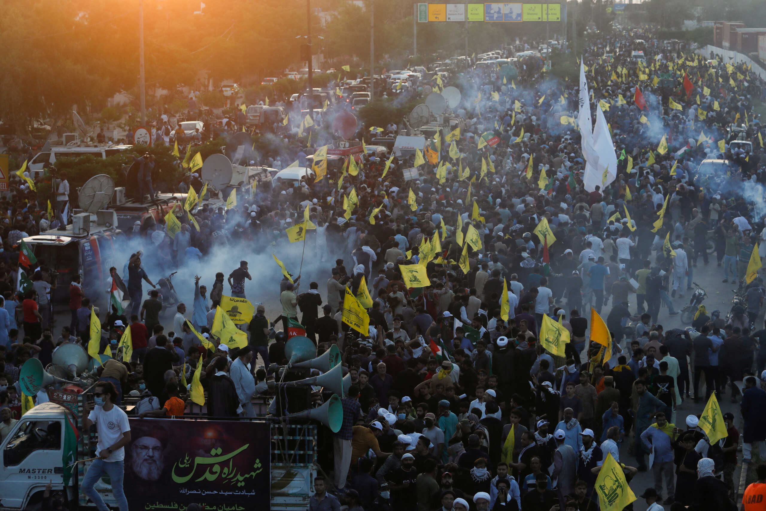 Pakistani Shi'ite Muslims carry flags as they protest the killing of Lebanon's Hezbollah leader Sayyed Hassan Nasrallah in an Israeli air strike in Beirut, amid tear gas smoke fired by police to disperse them as they march towards the U.S. Consulate in Karachi, Pakistan September 29, 2024. REUTERS