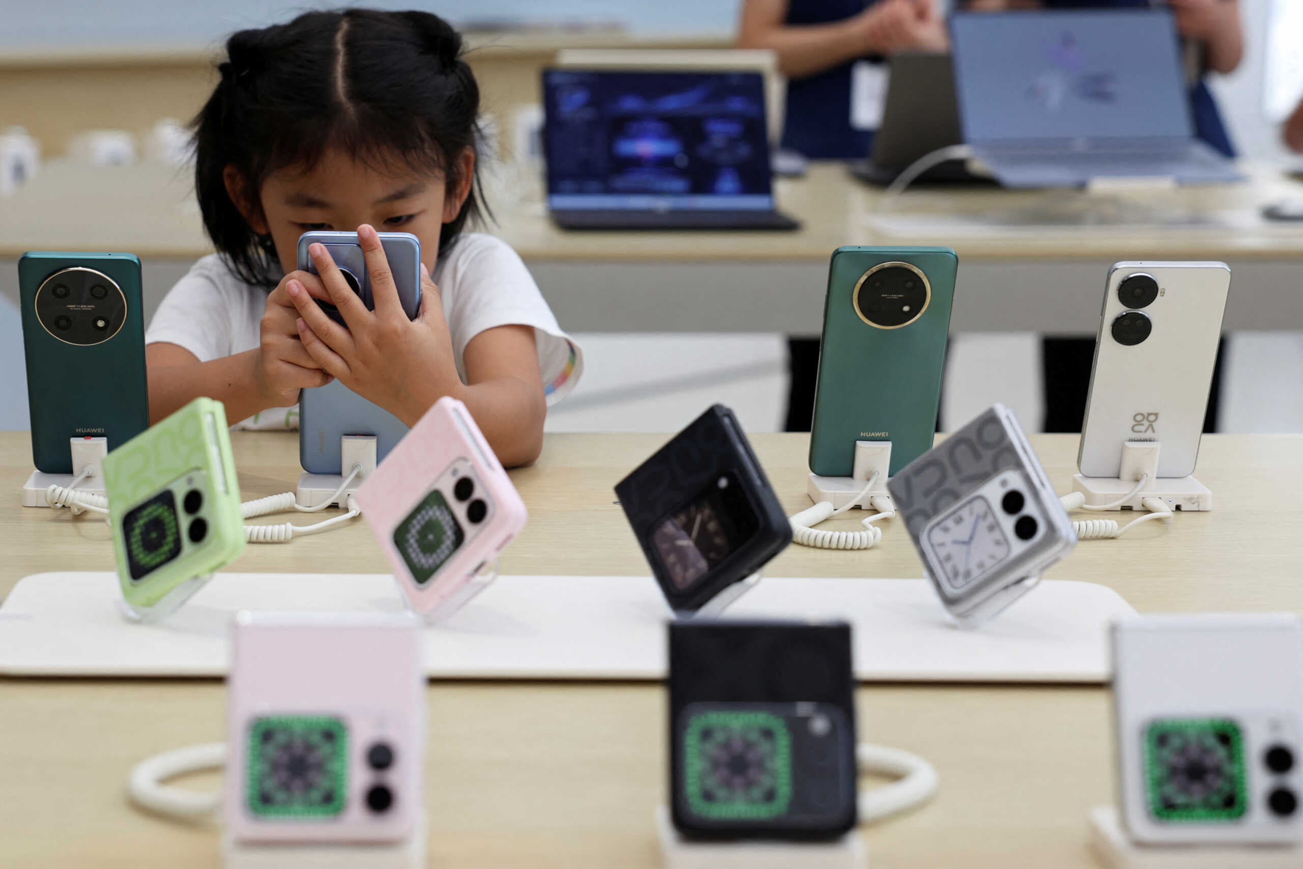 A child checks a Huawei Nova smartphone displayed at a Huawei flagship store in Beijing, China September 10, 2024. REUTERS