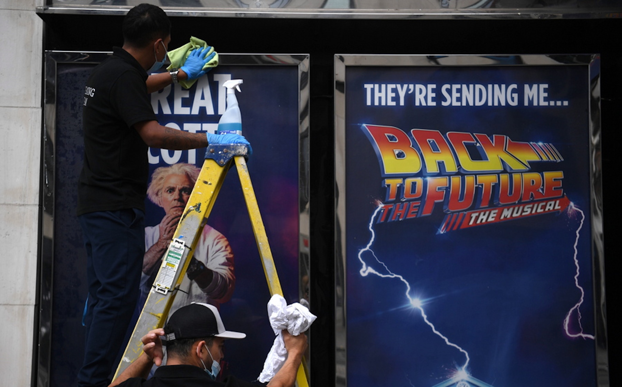 epa09465512 A man cleans an advertisement for the 'Back to the Future' stage show at the Adelphi Theatre in London, Britain, 13 September 2021. West End theaters have been hit hard due to the coronavirus disease (COVID-19) pandemic but have re-opened with new shows such as 'Cinderella,' 'Back to the Future' and 'Frozen.'  EPA