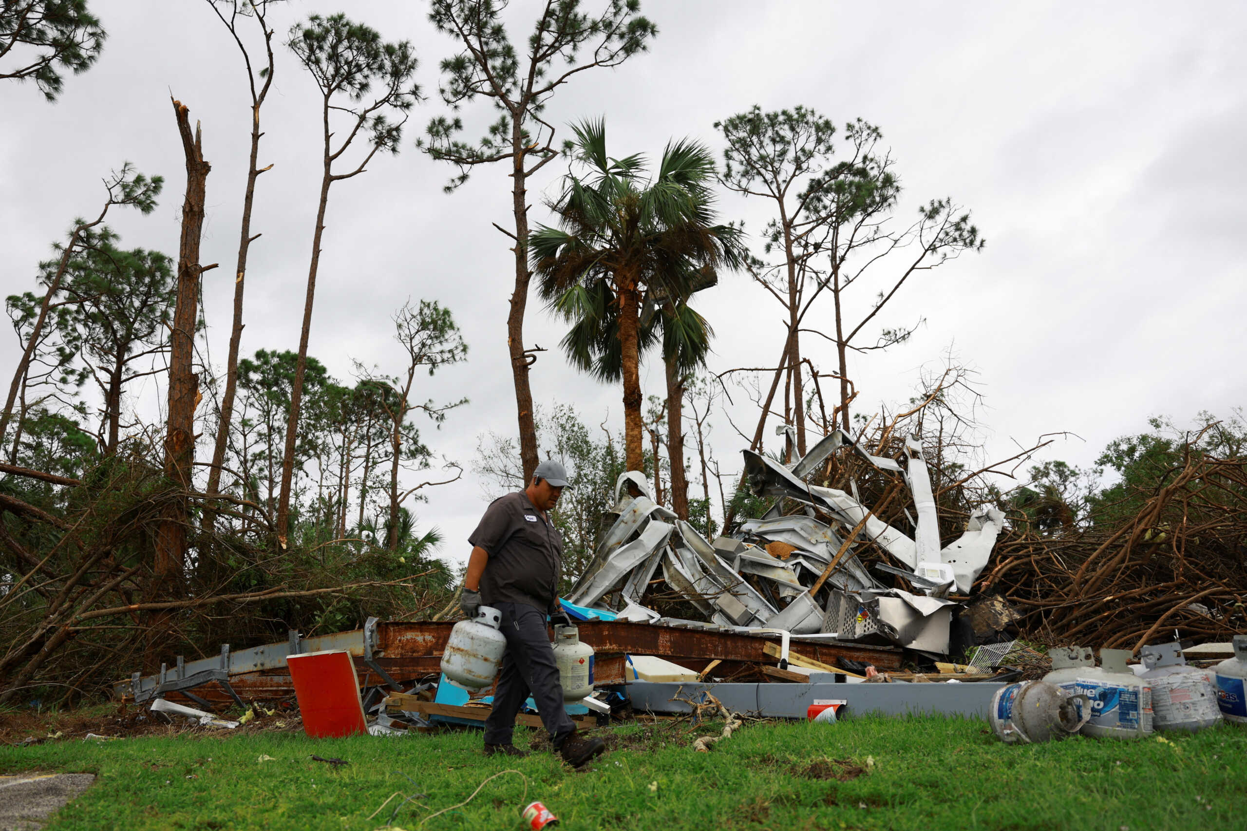 A man collects gas tanks at a gas station destroyed by a tornado after Hurricane Milton made landfall, in Lakewood Park, near Fort Pierce, in St. Lucie County, Florida, Florida, U.S., October 10, 2024.  REUTERS